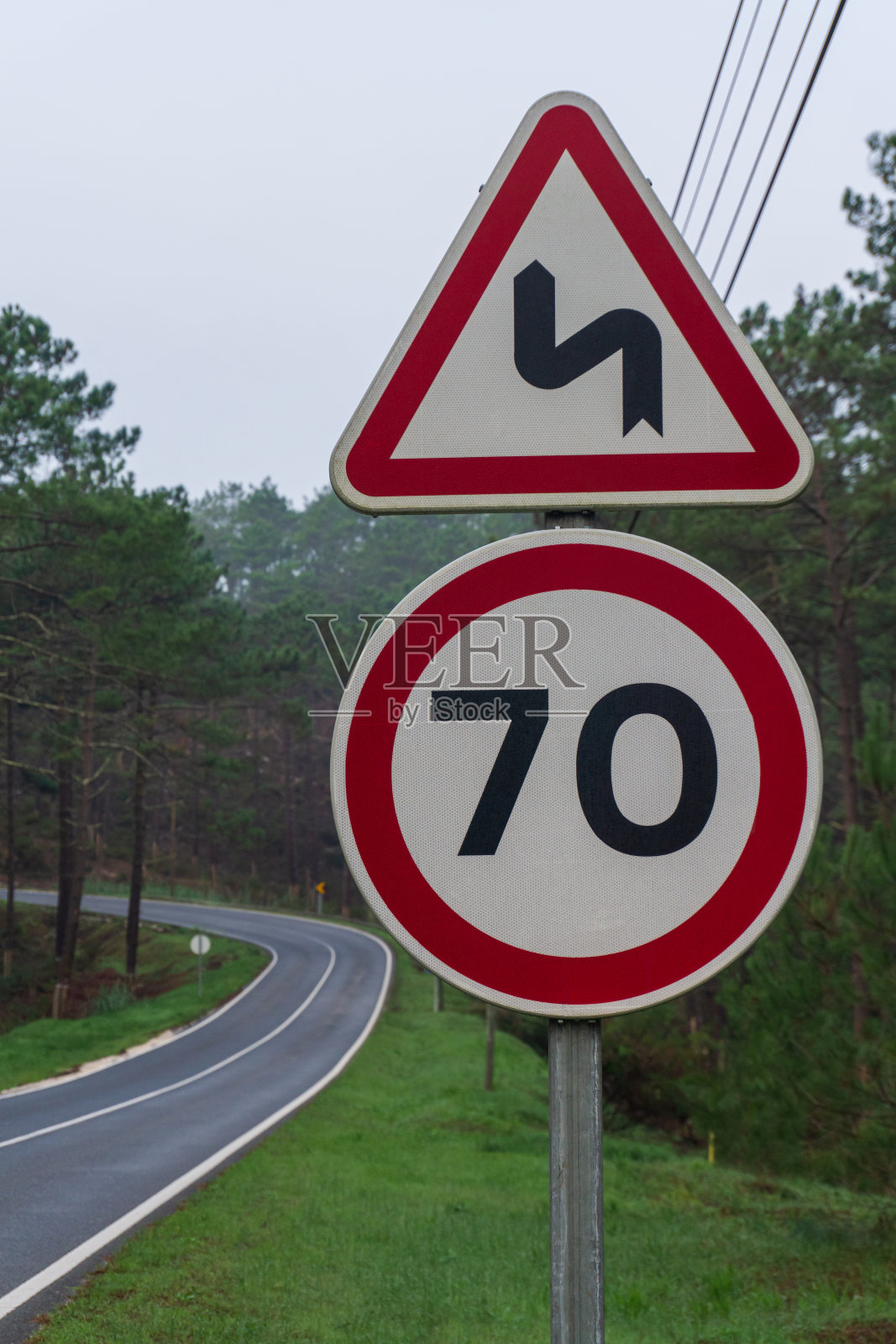 道路上有红色的路标，在布满针叶林的山间穿行照片摄影图片