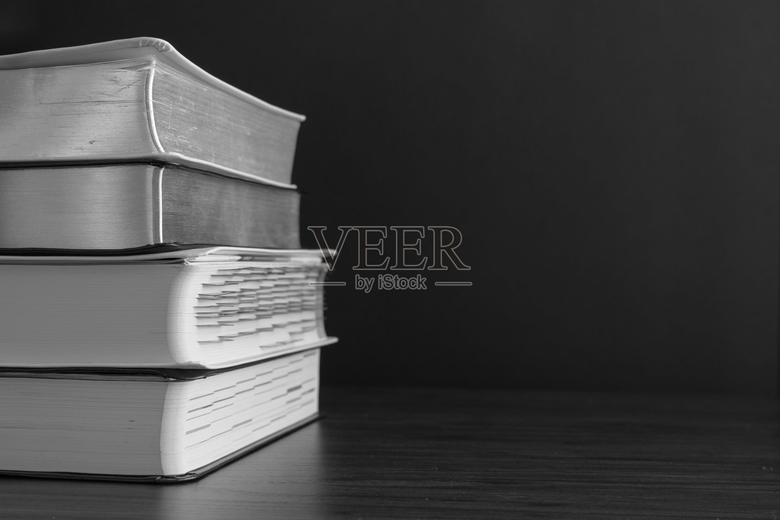 黑色背景上的一摞书照片摄影图片