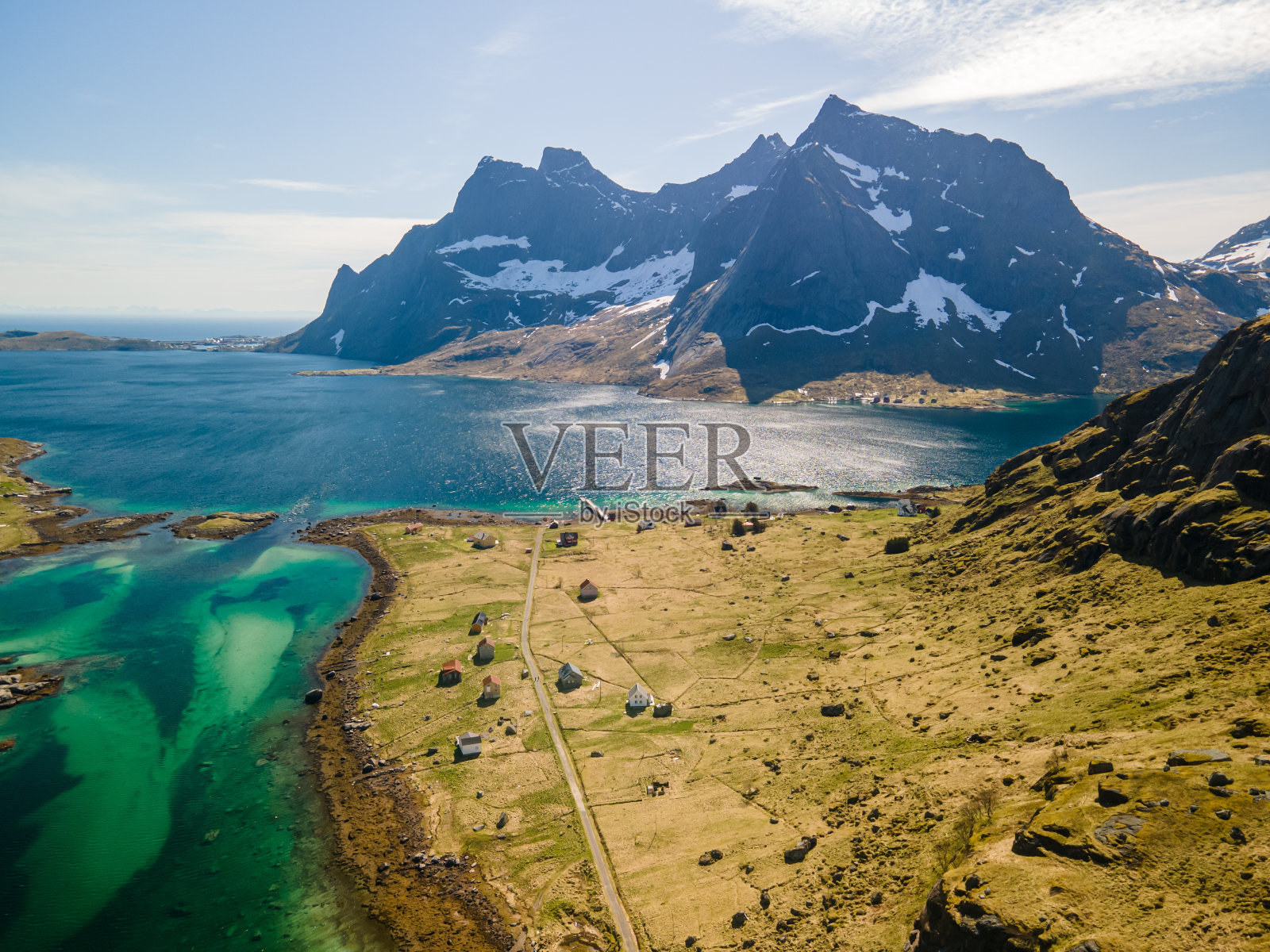 挪威罗弗敦的Vindstad村的无人机鸟瞰图，彩色的小房子，大山和蓝色的湖泊，在一个晴朗的春天，有云照片摄影图片