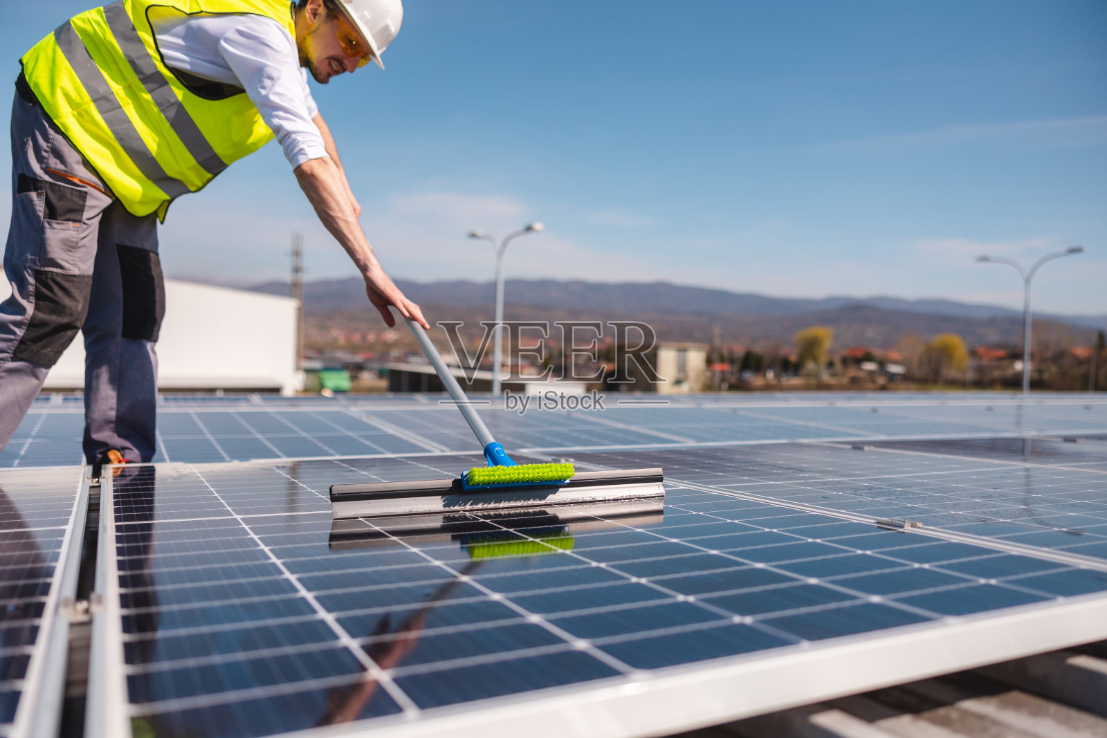 一个年轻人清洁太阳能电池板的特写镜头照片摄影图片