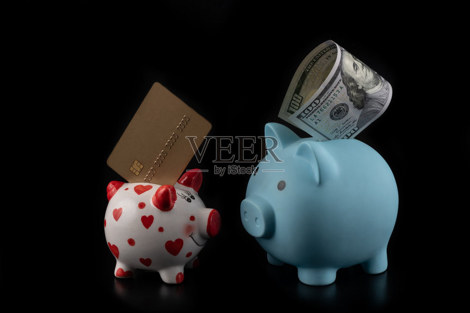 两个储蓄罐，一张信用卡和一张100美元的黑底钞票照片摄影图片