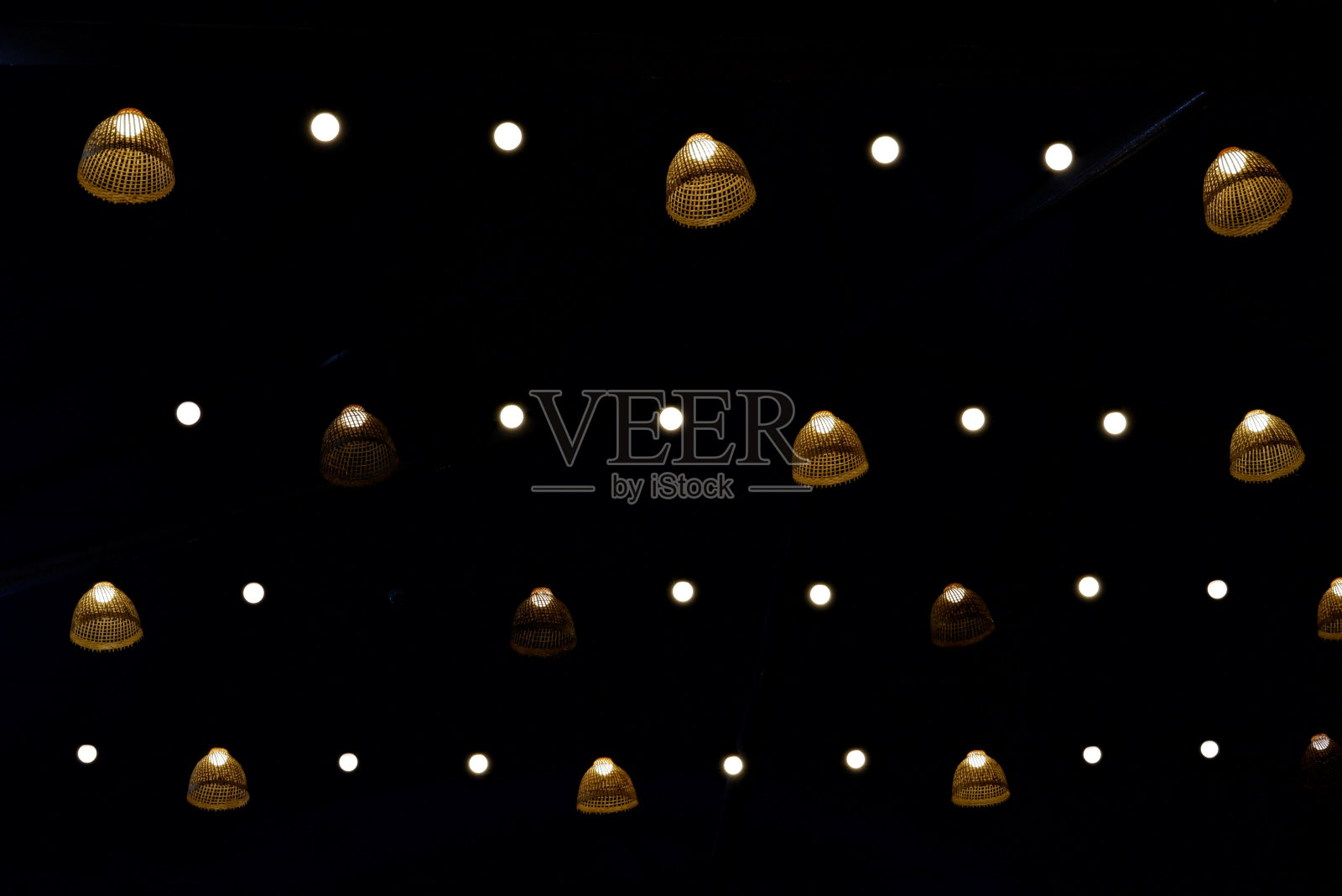在选择性聚焦中，一组竹灯泡悬挂在一个圆形，在黑暗的夜晚闪闪发光照片摄影图片