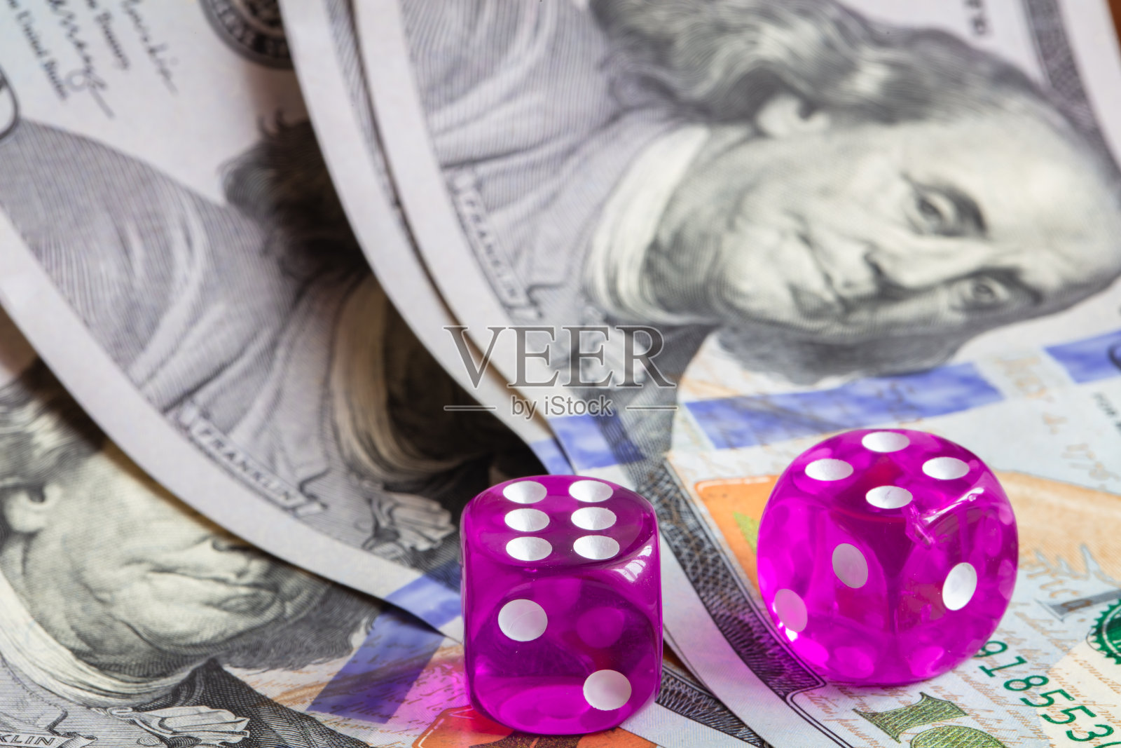 100美元纸币背景上有两个紫色的硬币照片摄影图片