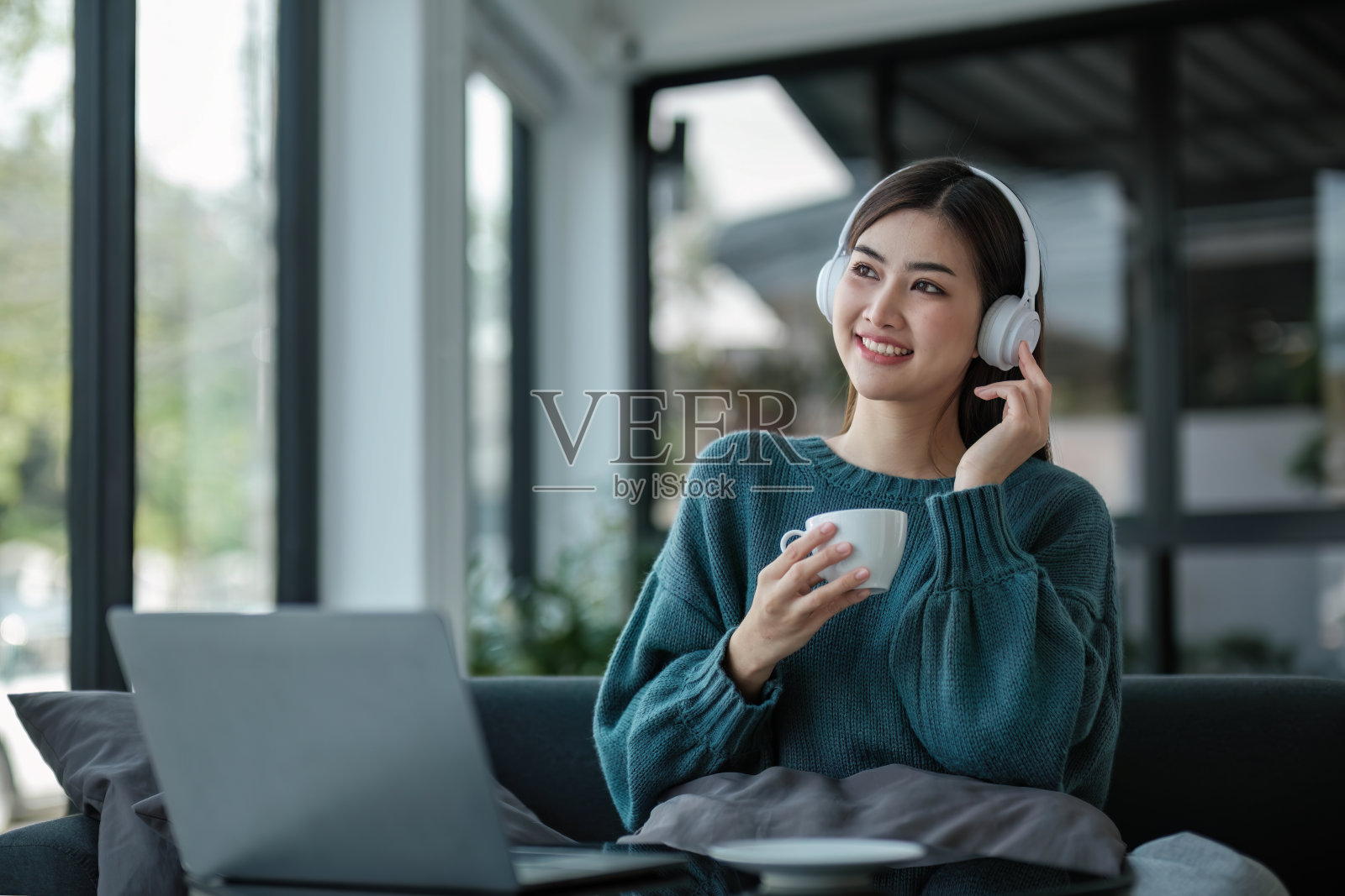 在家工作年轻的亚洲女性在笔记本电脑上工作，坐在家里拿着咖啡杯早上的生活方式概念照片摄影图片