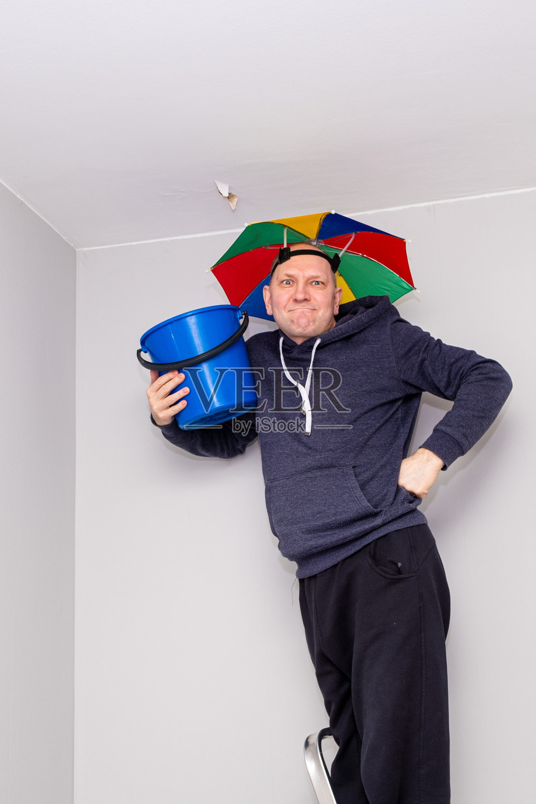 白人男子手里拿着一个蓝色的桶。男人很生气。照片摄影图片