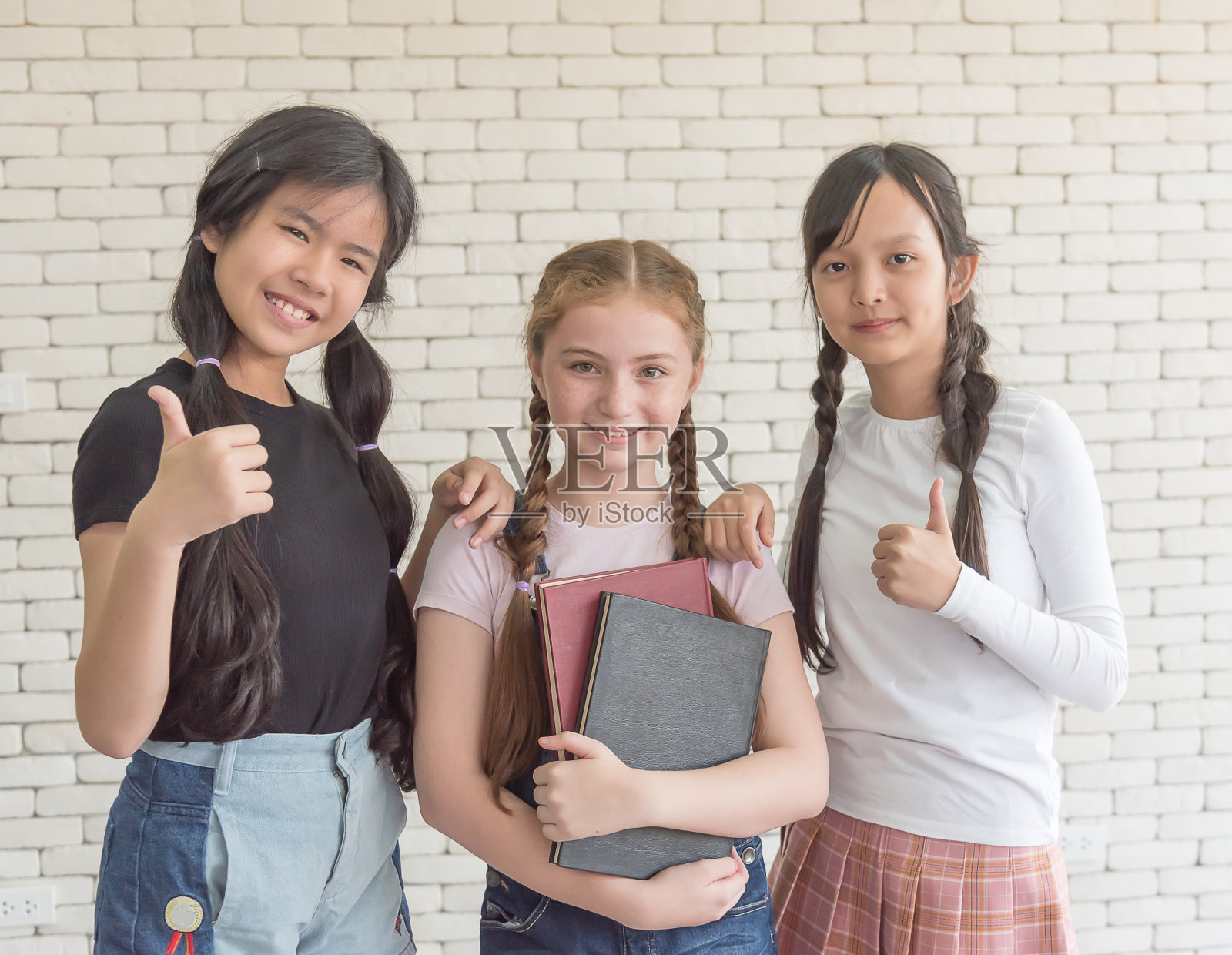 一所国际学校的三名女学生站起来竖起大拇指照片摄影图片