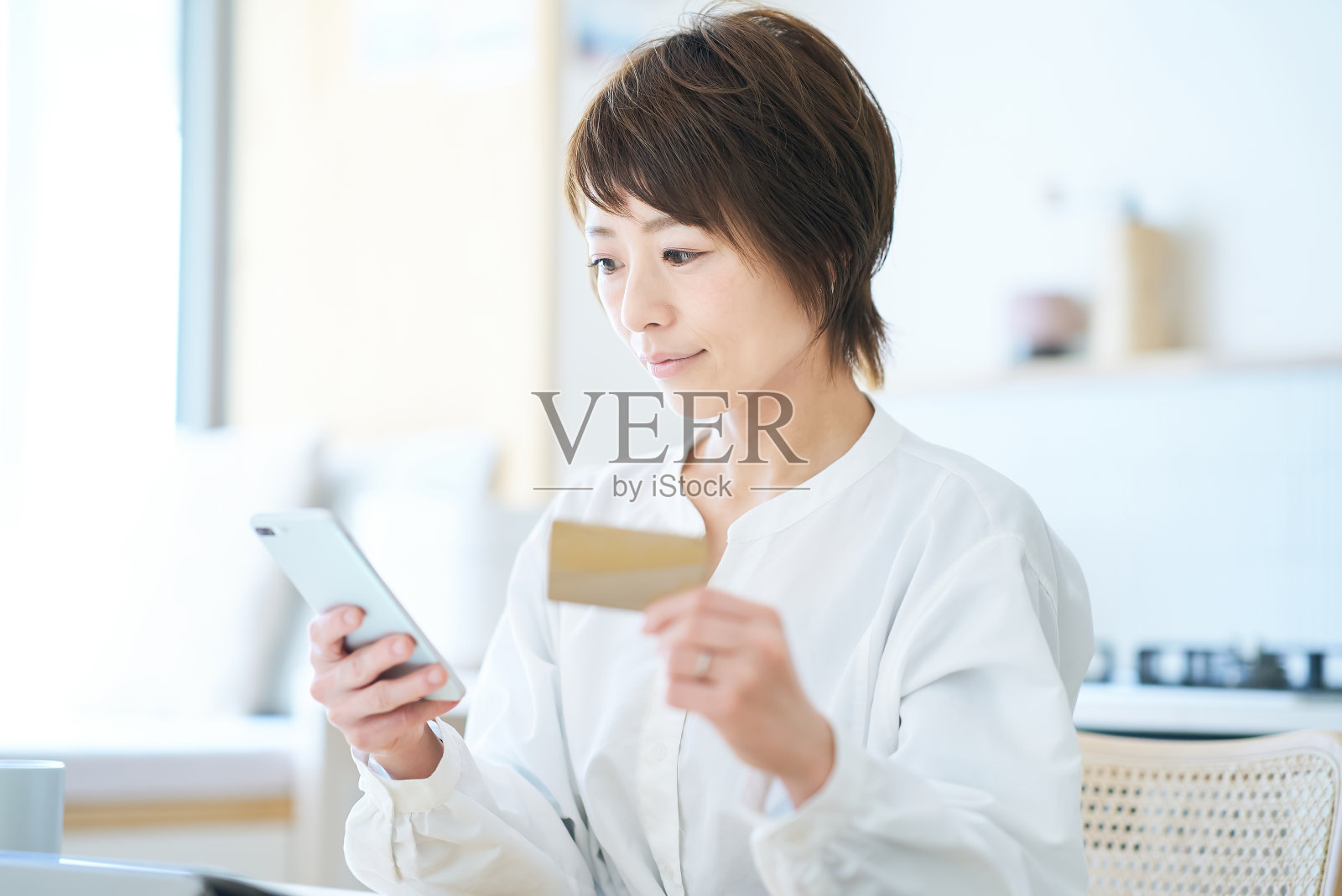 一名手持卡片并操作智能手机的妇女照片摄影图片