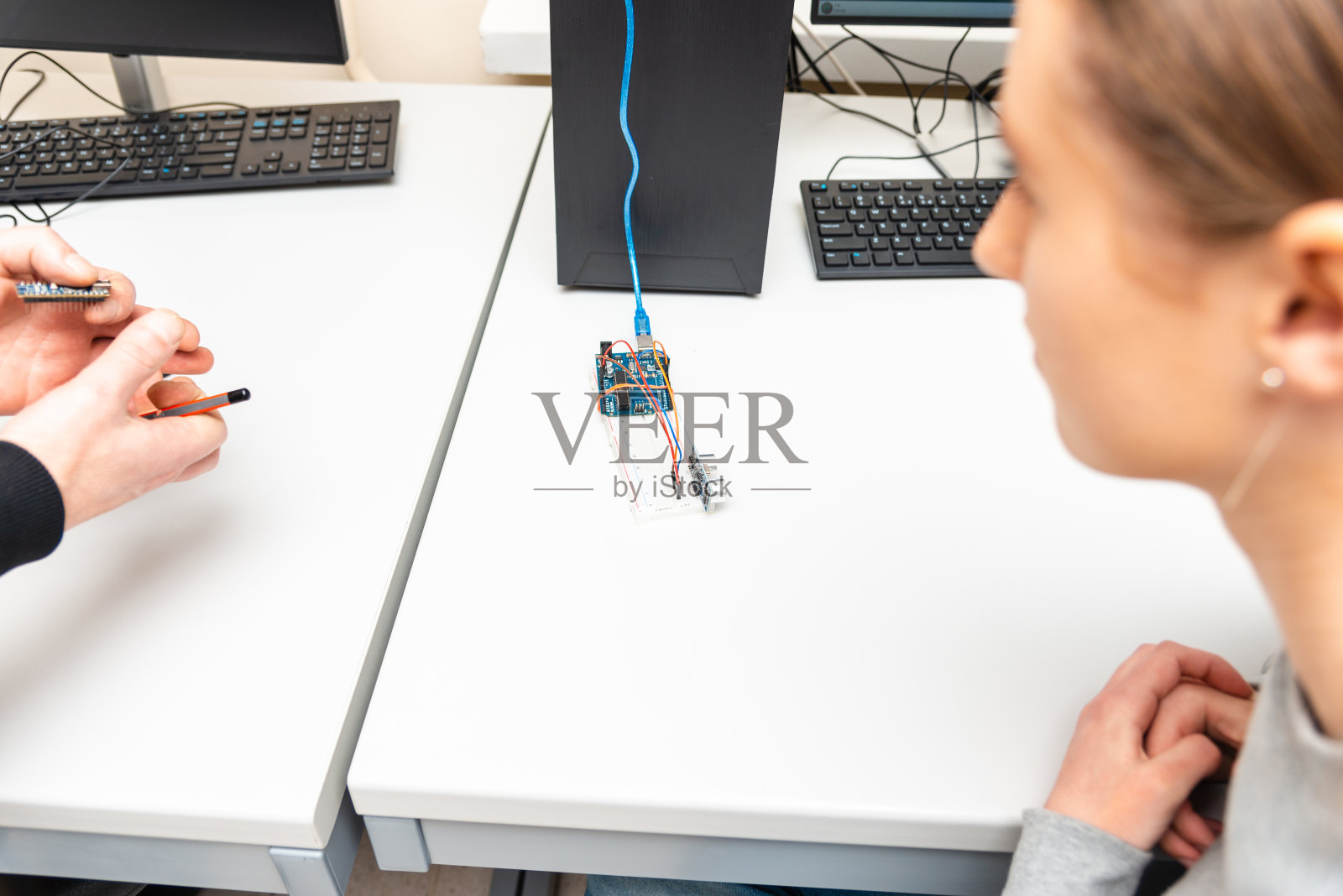 在stem教育课上，老师帮助他的十几岁的学生diy机器人。学生在校外计算机编程班建立和学习编程机器人车辆。Arduino超声波安装。照片摄影图片