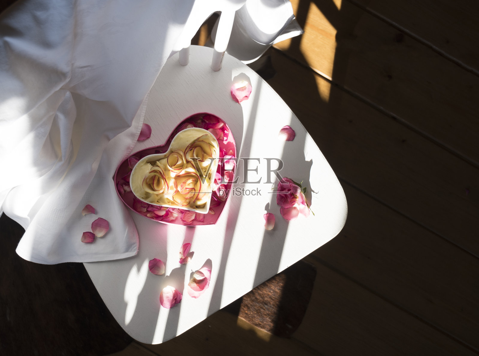 心形的苹果派站在白色的椅子上，散发着光芒照片摄影图片