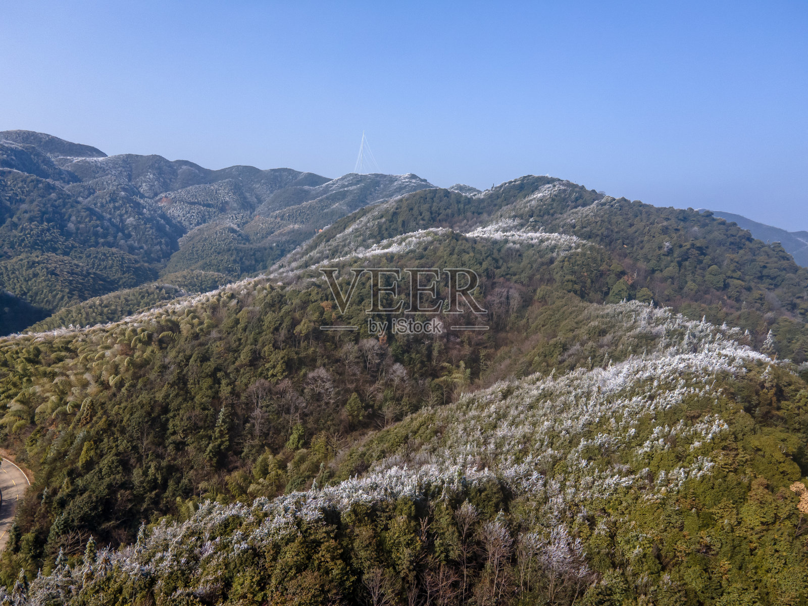 蓝天下的山林，有一层薄薄的雾凇照片摄影图片