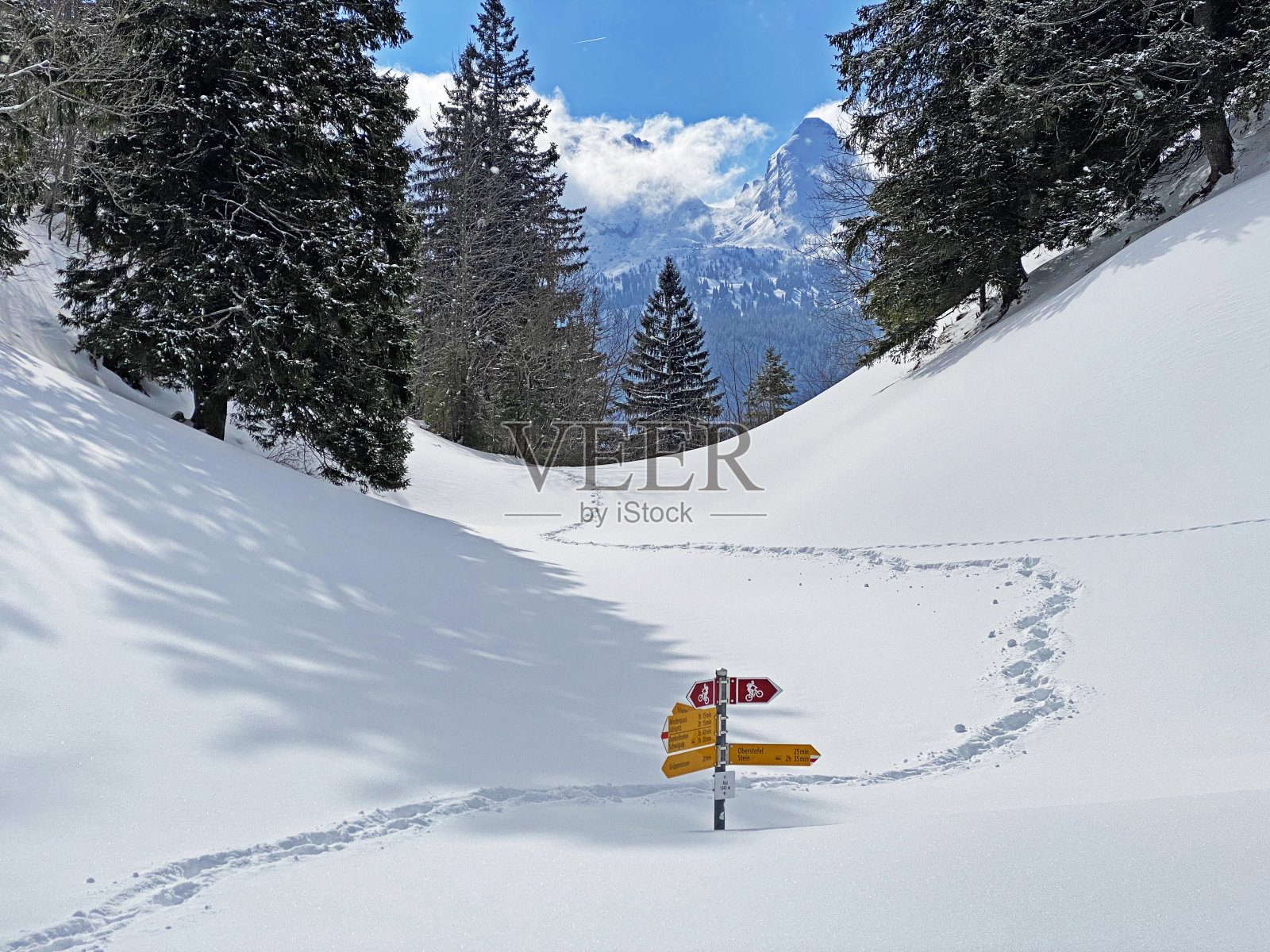 徒步旅行标志和方向标志，用于在阿尔卑斯山脉和瑞士阿尔卑斯山脉的田园诗般的冬季氛围中导航-瑞士(瑞士)Unterwasser照片摄影图片