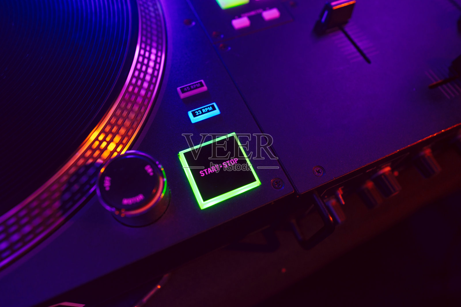 在派对灯光下的DJ混合控制台的特写照片摄影图片
