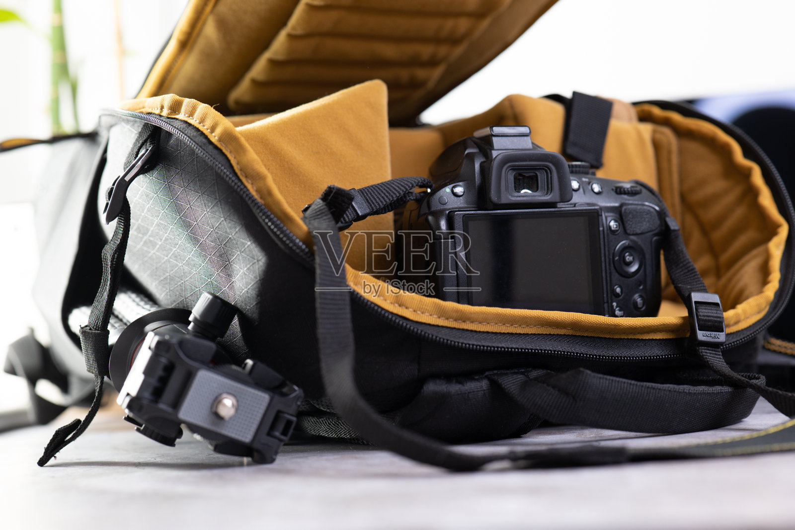 时尚的相机包与配件在灰色桌子上。专业摄影设备。照片摄影图片