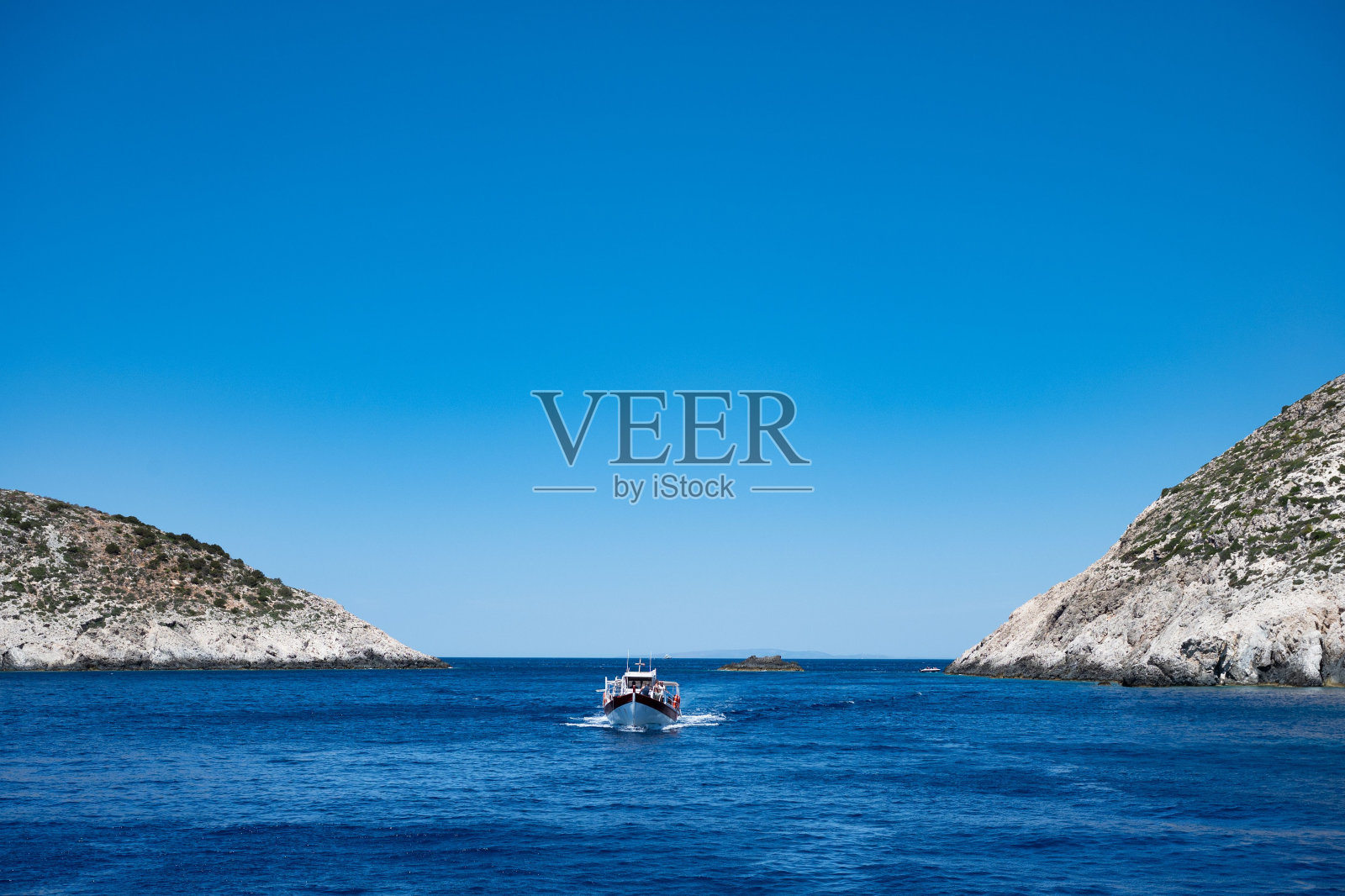 希腊扎金索斯，一艘小船在被山峰环绕的宁静湖中航行照片摄影图片