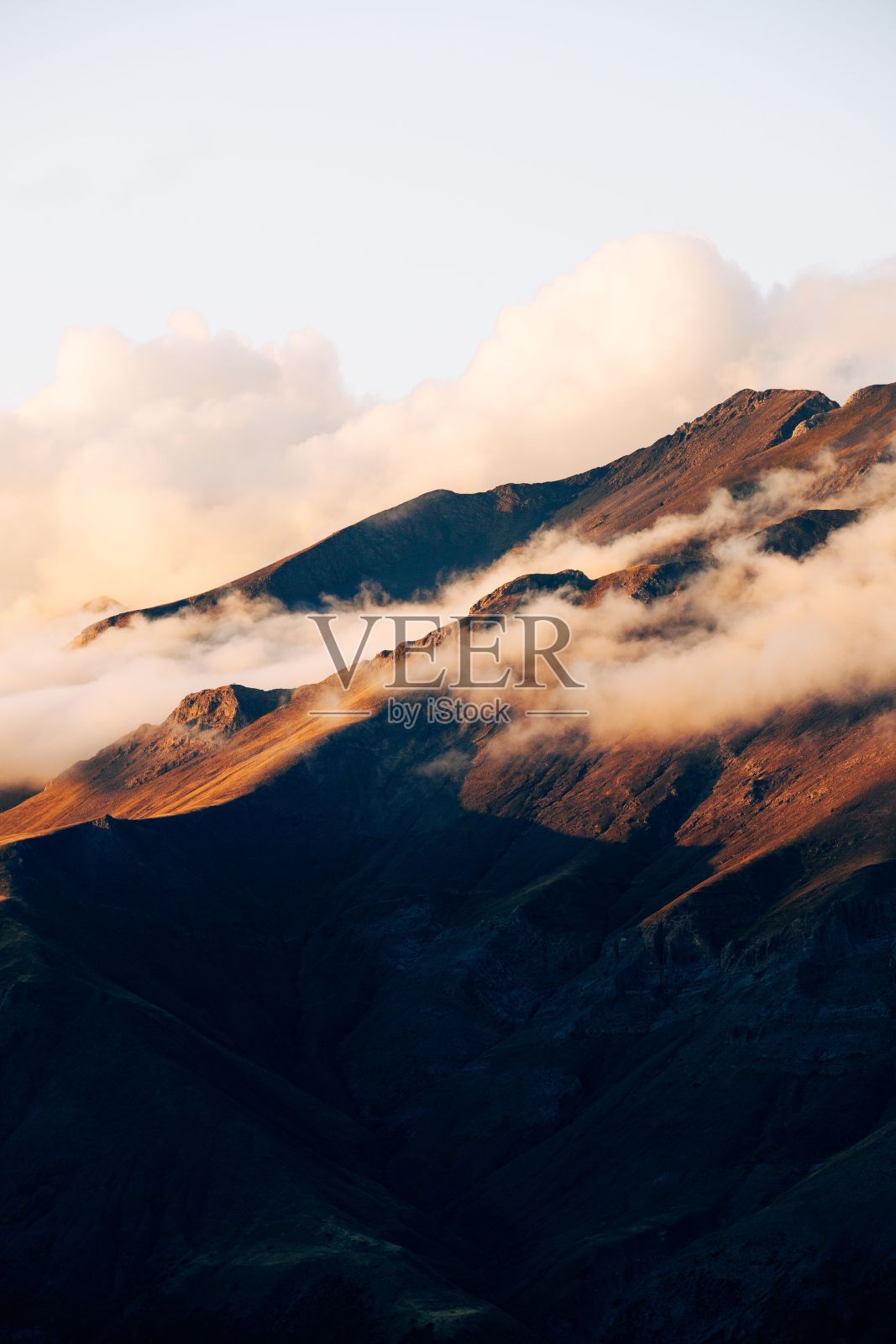 风景如画的起伏的山丘和低洼的云被柔和的环境光照亮照片摄影图片