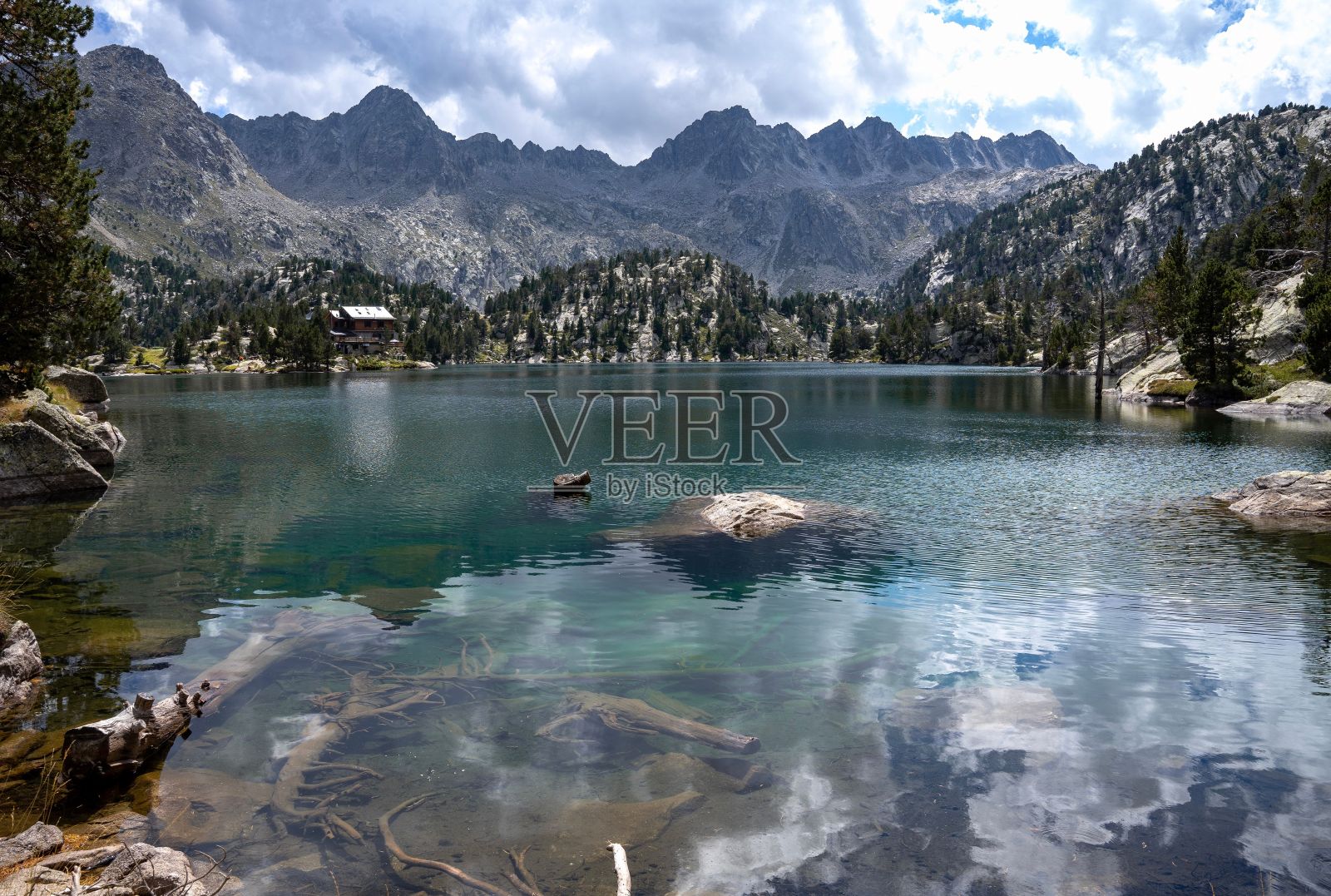 在阴沉的日子里，一个被落基山脉环绕的宁静湖泊的景观照片摄影图片