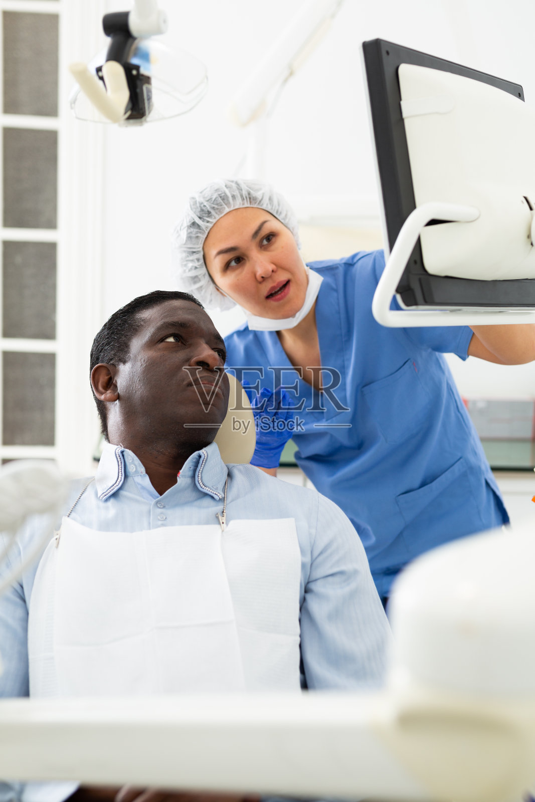 牙医医生给病人看x光片照片摄影图片