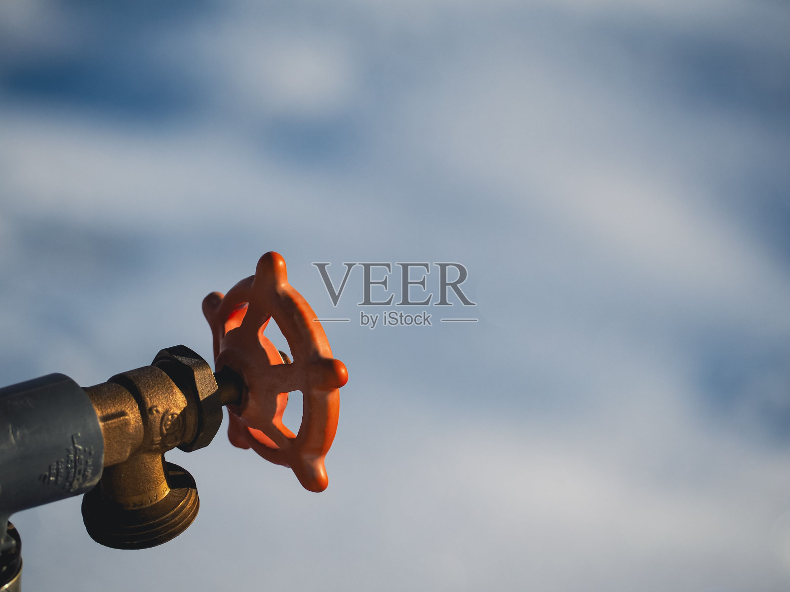 一个带有喷嘴和手柄的橙色水表的特写镜头照片摄影图片