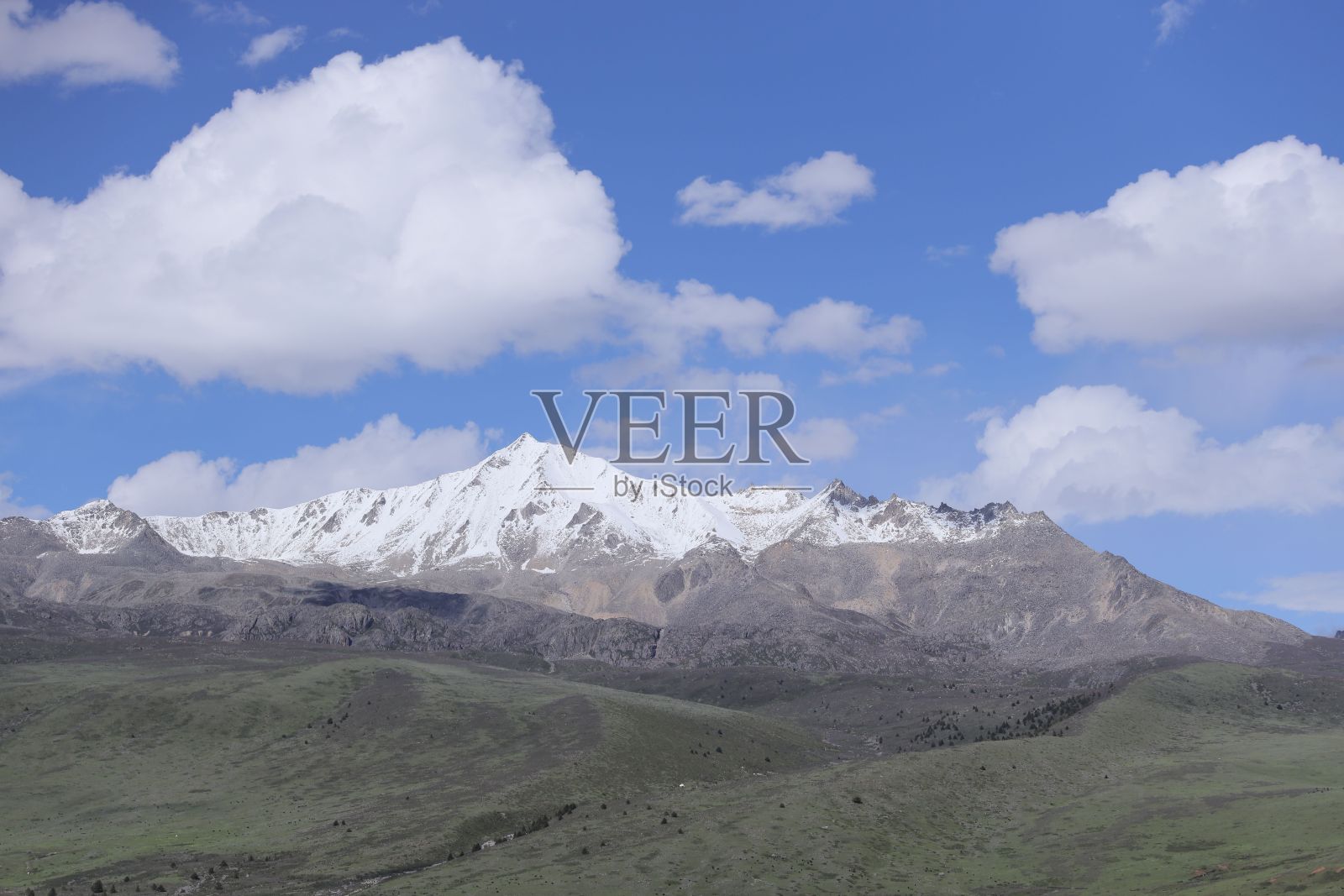 雄伟的雪山映衬着蓝天白云。照片摄影图片