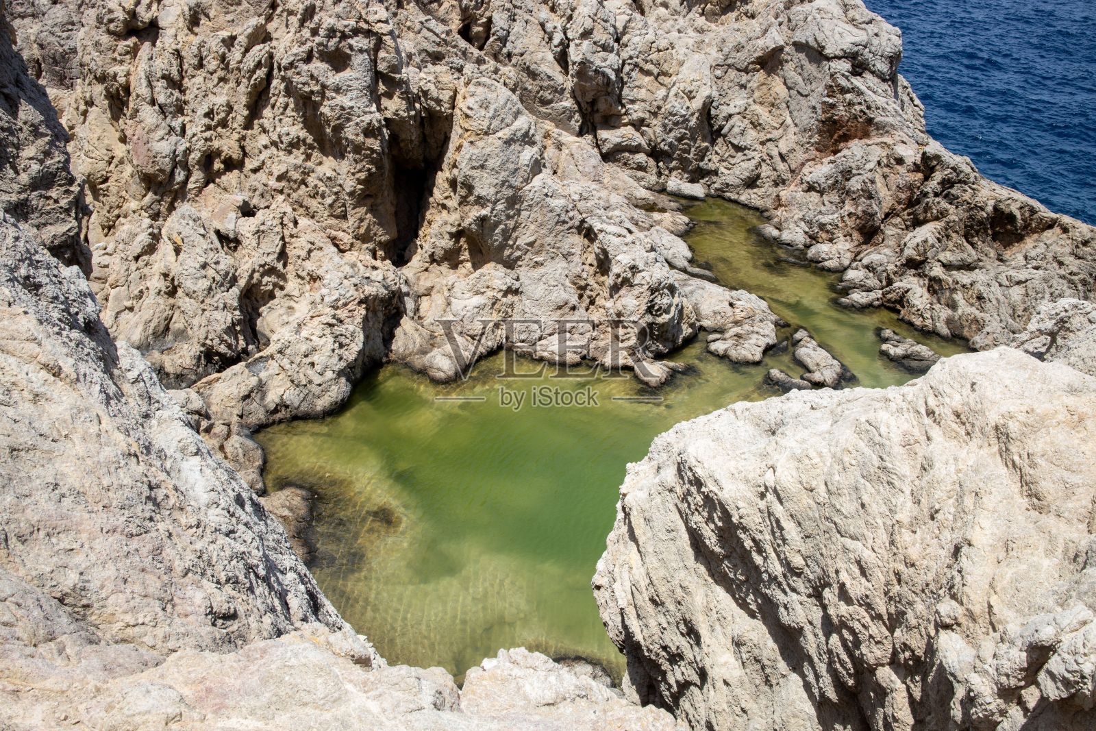 在海岸的岩石上有一些绿色的水照片摄影图片