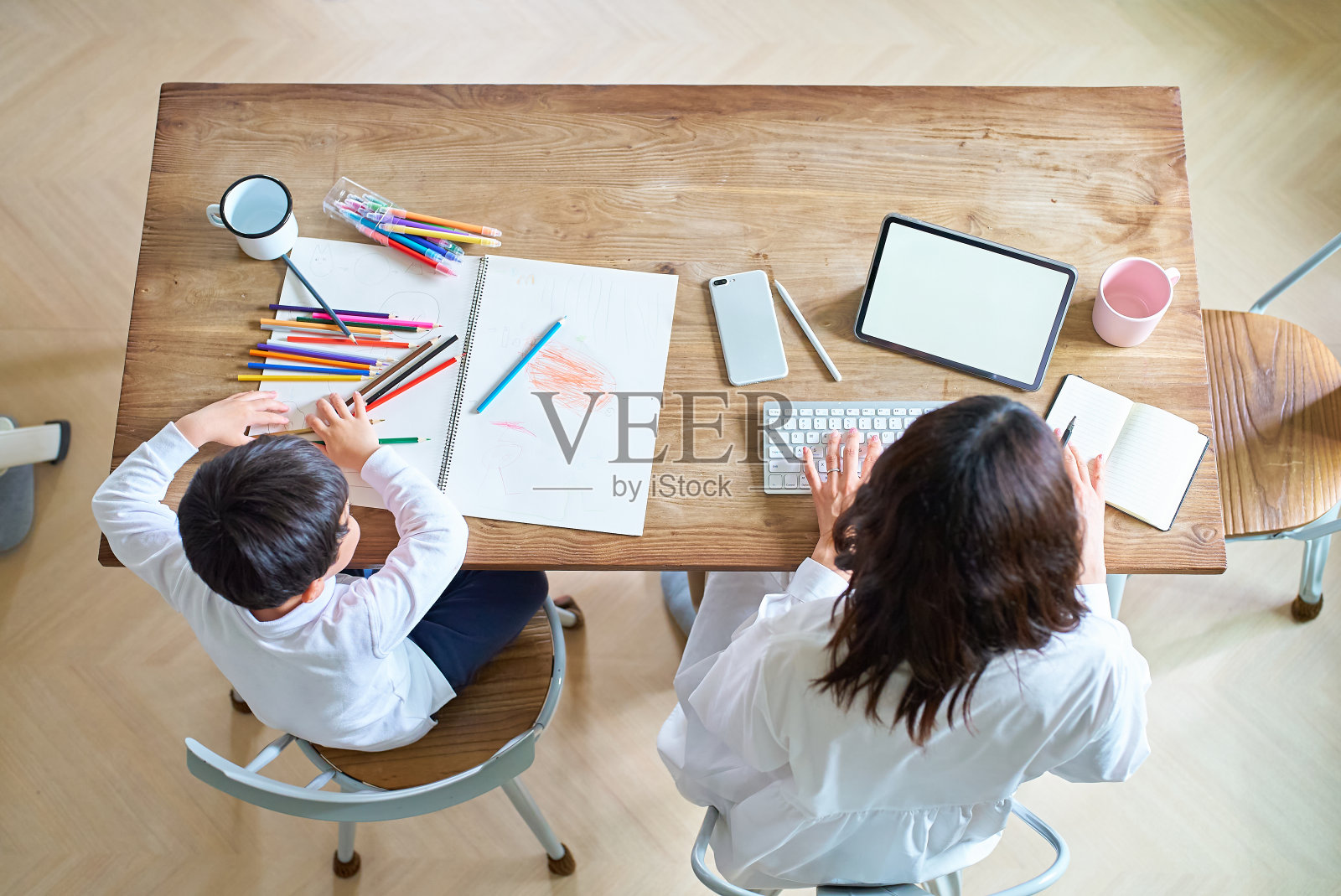 母亲在工作，孩子在画画照片摄影图片