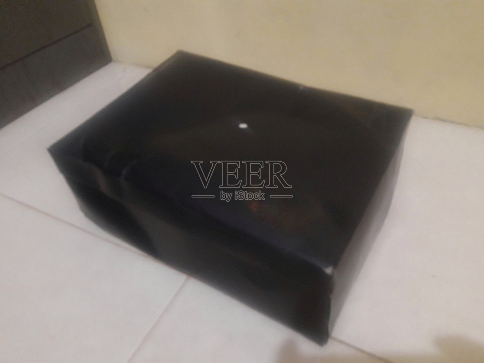 仔细观察地板上的黑色鞋盒照片摄影图片