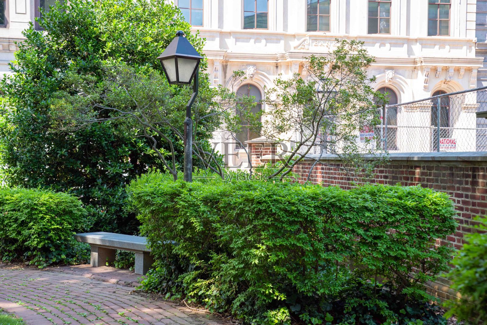 城市公园里有灌木和红砖的空长椅照片摄影图片