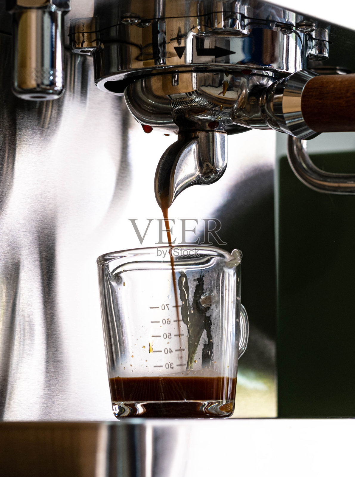 咖啡从冲泡棒流入量杯照片摄影图片
