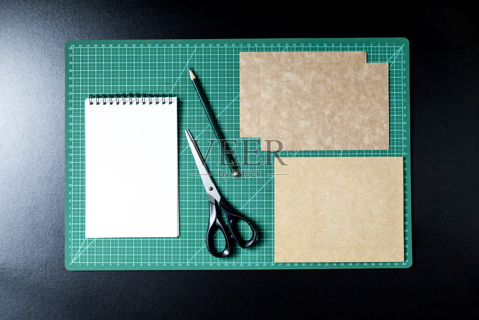 用剪贴板，便签笔，铅笔，剪刀和纸板制作桌子。照片摄影图片