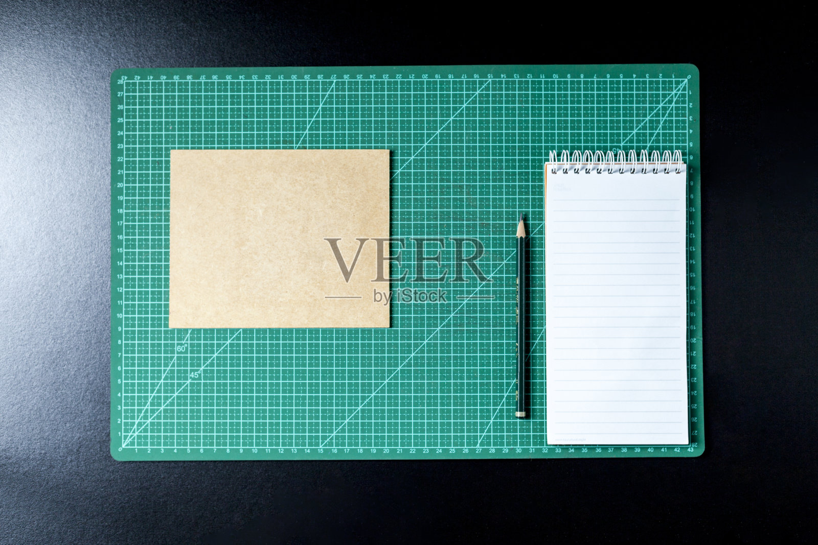 用剪贴板，便签笔，铅笔，剪刀和纸板制作桌子。照片摄影图片