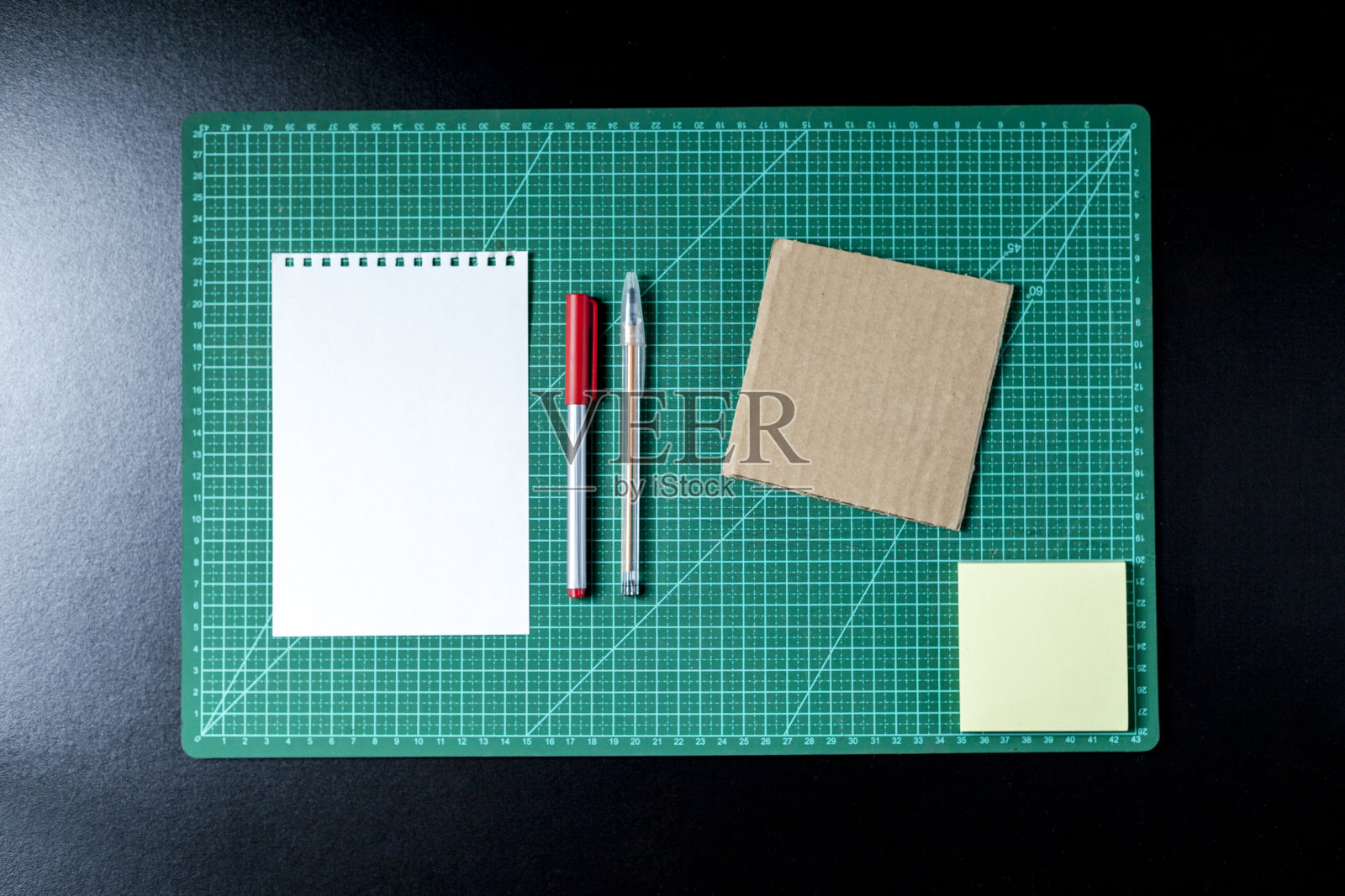 用剪贴板，便签笔，铅笔，剪刀和纸板制作桌子。照片摄影图片