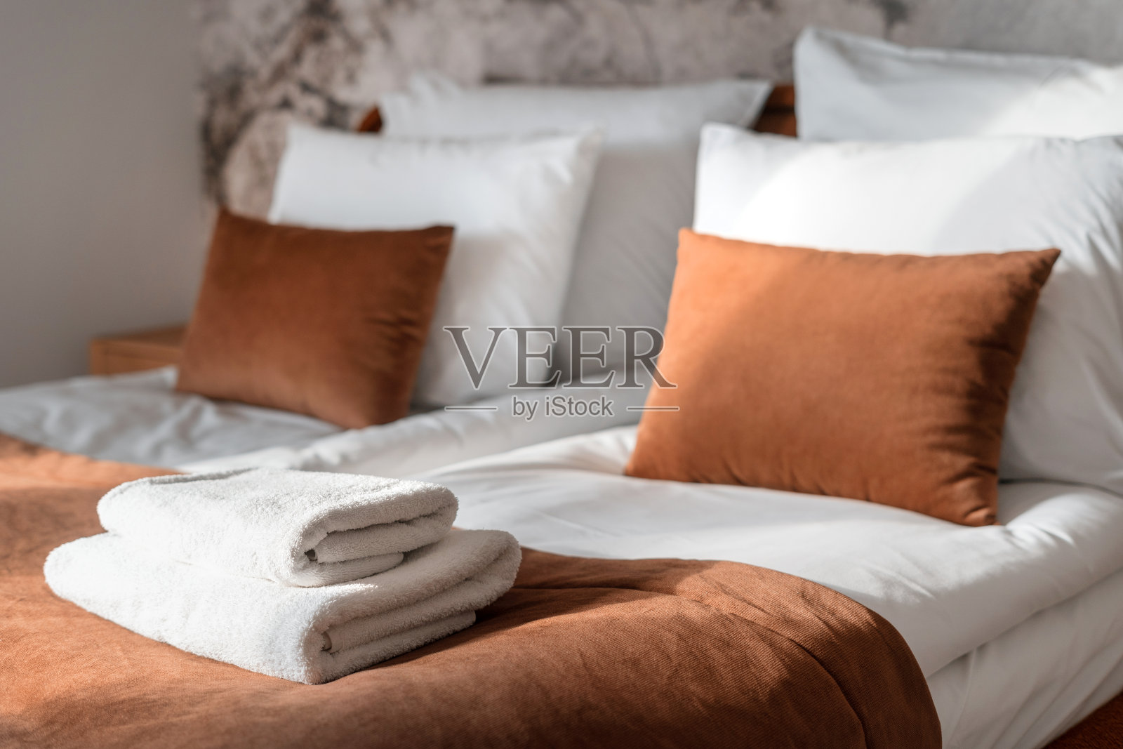 舒适的卧室，干净的浴巾，靠垫和床上用品照片摄影图片