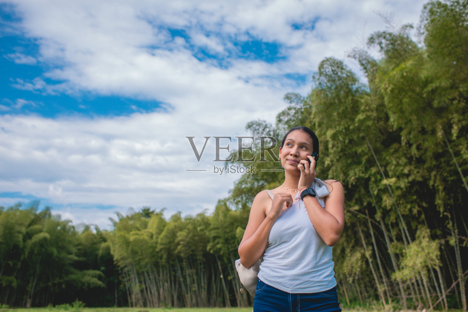 一名年轻女子站在河边。照片摄影图片