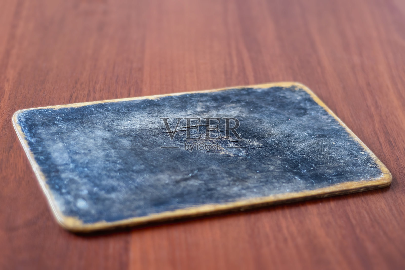 一块有刀痕和黑色烧焦表面的旧木砧板。用于烹饪食物的老式厨房用具。照片摄影图片