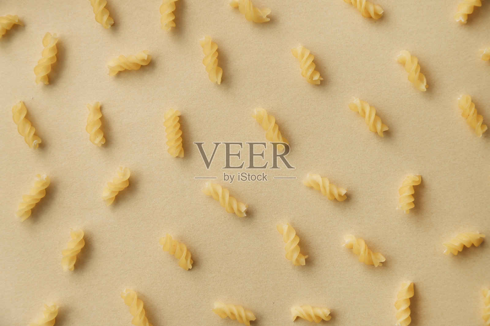 螺旋面图案的俯视图。中性背景的生意大利面，平铺。小麦食品概念。照片摄影图片
