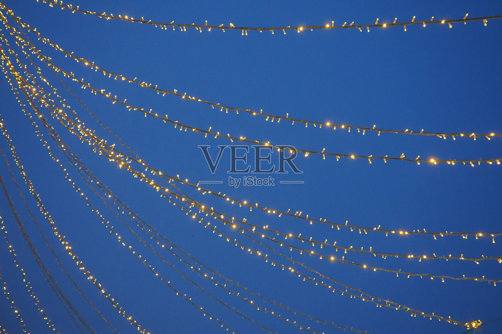 黄色的花环映衬着夜空。散焦散景。新年和圣诞节照片摄影图片
