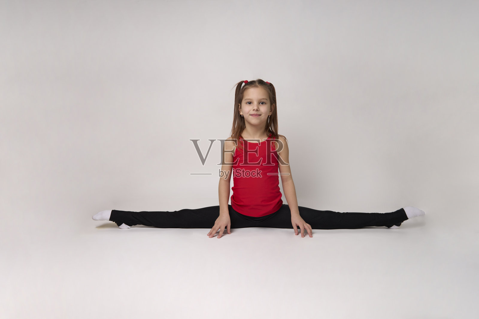 白色背景上的年轻女孩体操运动员照片摄影图片