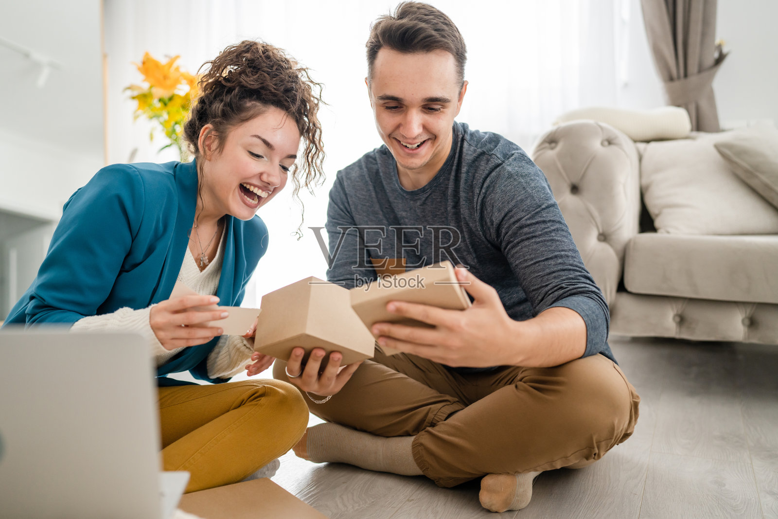 男人拿着和阅读贺卡，同时拿着和打开礼物，礼品盒在家里与女友视频通话快乐的微笑复制空间真实的人高加索成年人照片摄影图片
