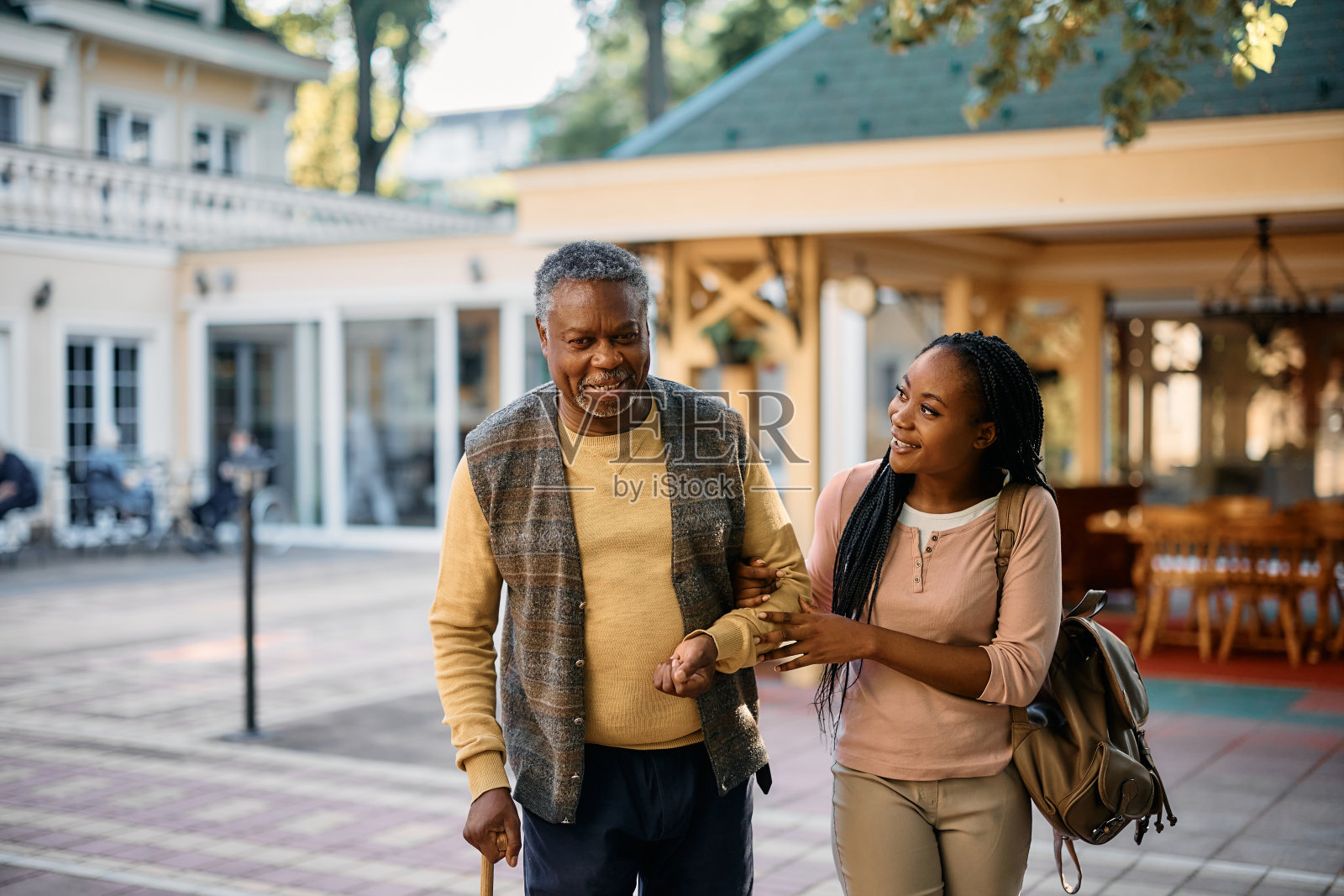 年轻的黑人女性去养老院看望年迈的父亲。照片摄影图片