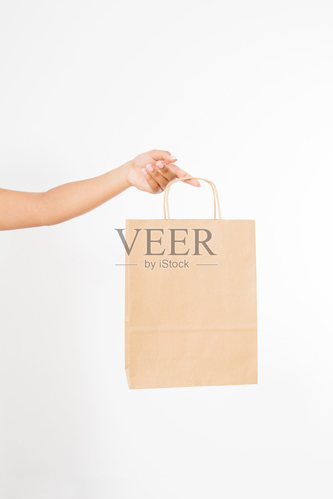 模板空白包。非洲裔美国妇女手拿一个纸牛皮袋孤立的白色背景。送货和购物概念。照片摄影图片