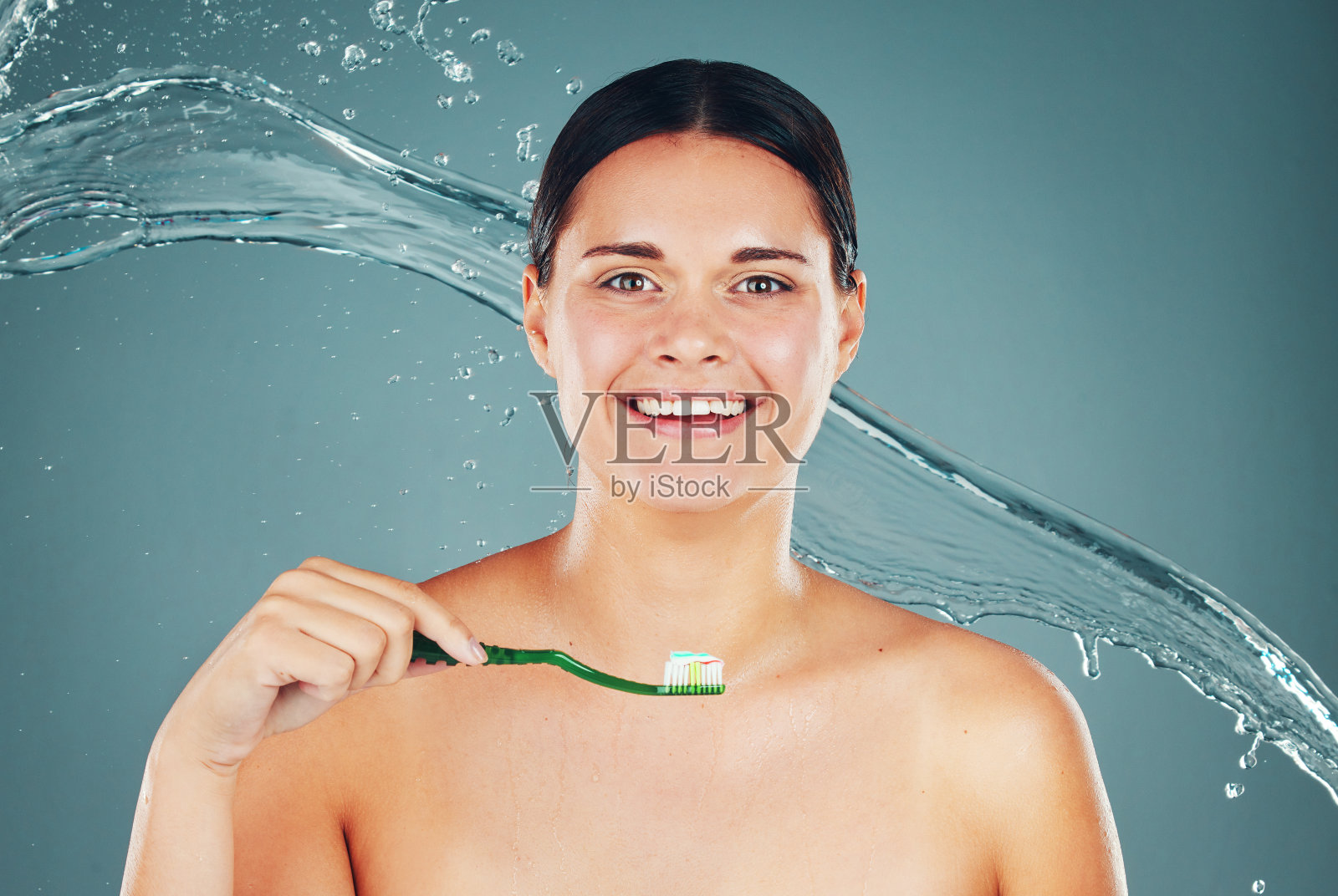 快乐，梳理和肖像的一个女人刷牙孤立在蓝色的背景。水花飞溅，健康而干净的脸，微笑着年轻的模特用牙膏照顾牙齿卫生照片摄影图片