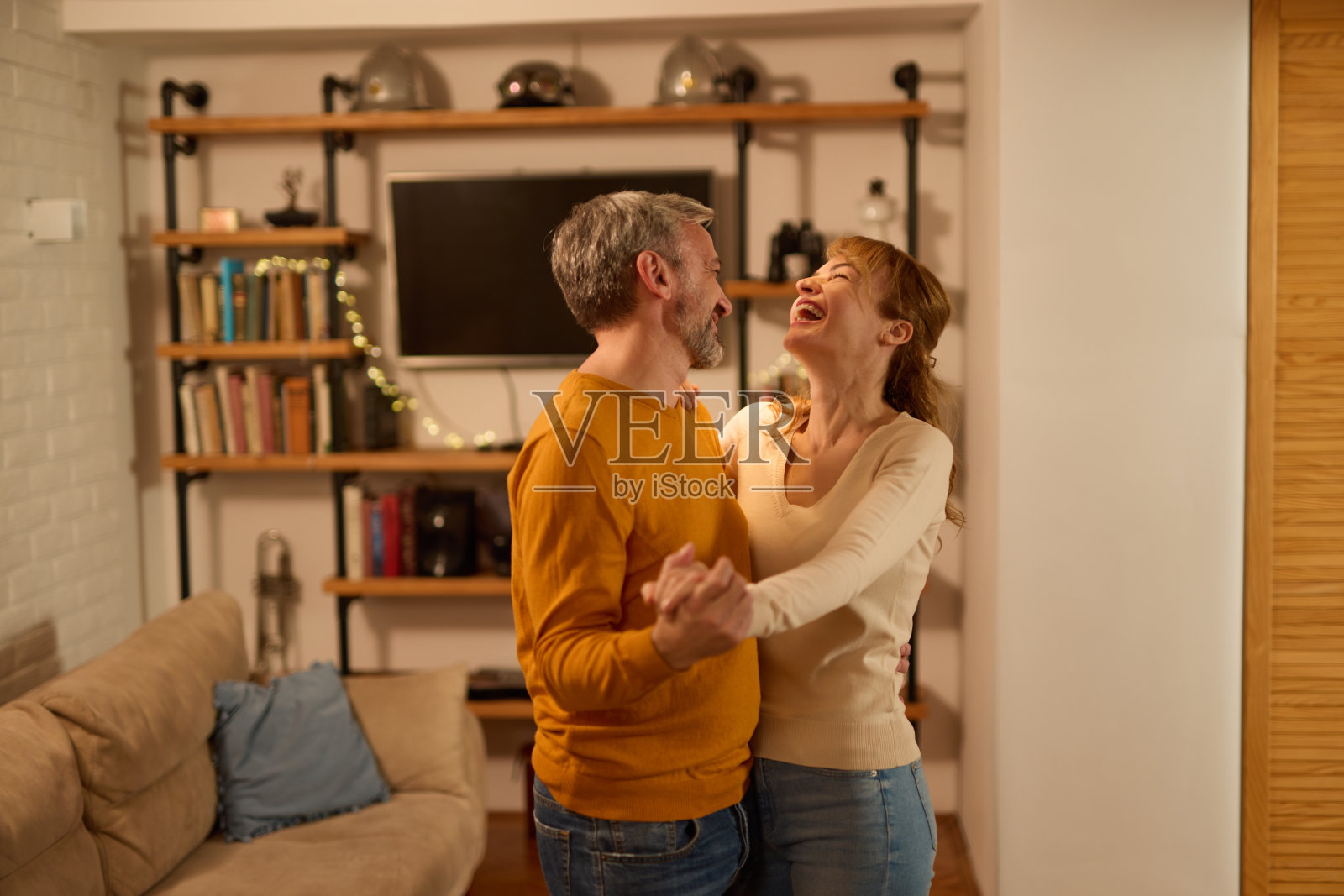 成熟的夫妇一起跳舞在现代客厅在家里照片摄影图片