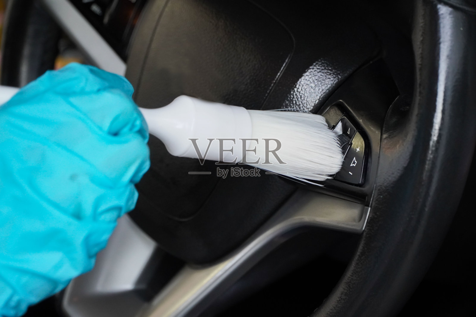 洗车的细节概念。白色软鬃毛刷清洁和清除方向盘上的污垢。汽车细节系列照片摄影图片