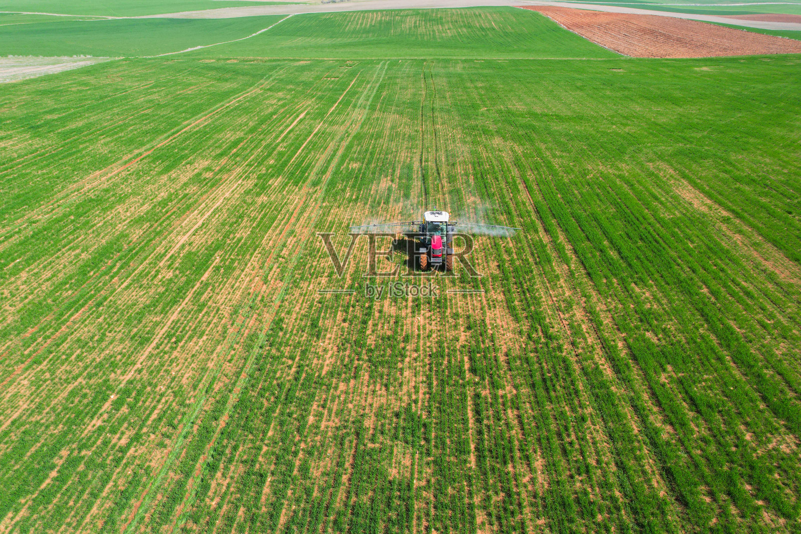 用红色拖拉机喷洒农田航拍照片摄影图片