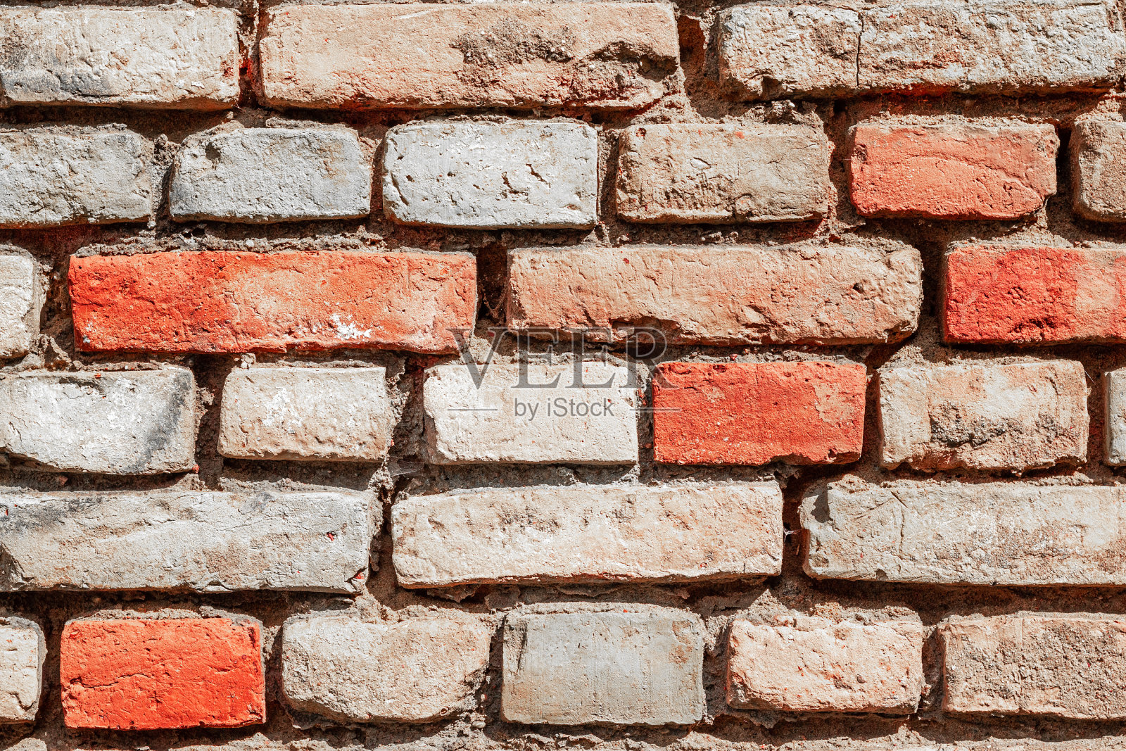 用红色和灰色的旧砖砌成的墙。纹理背景。文化遗产的概念。照片摄影图片