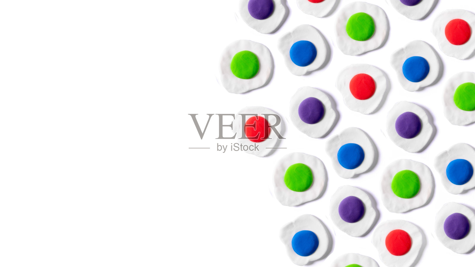 白色背景上彩色蛋黄的软糖煎蛋图案。最小抽象的创意概念。建模粘土。照片摄影图片