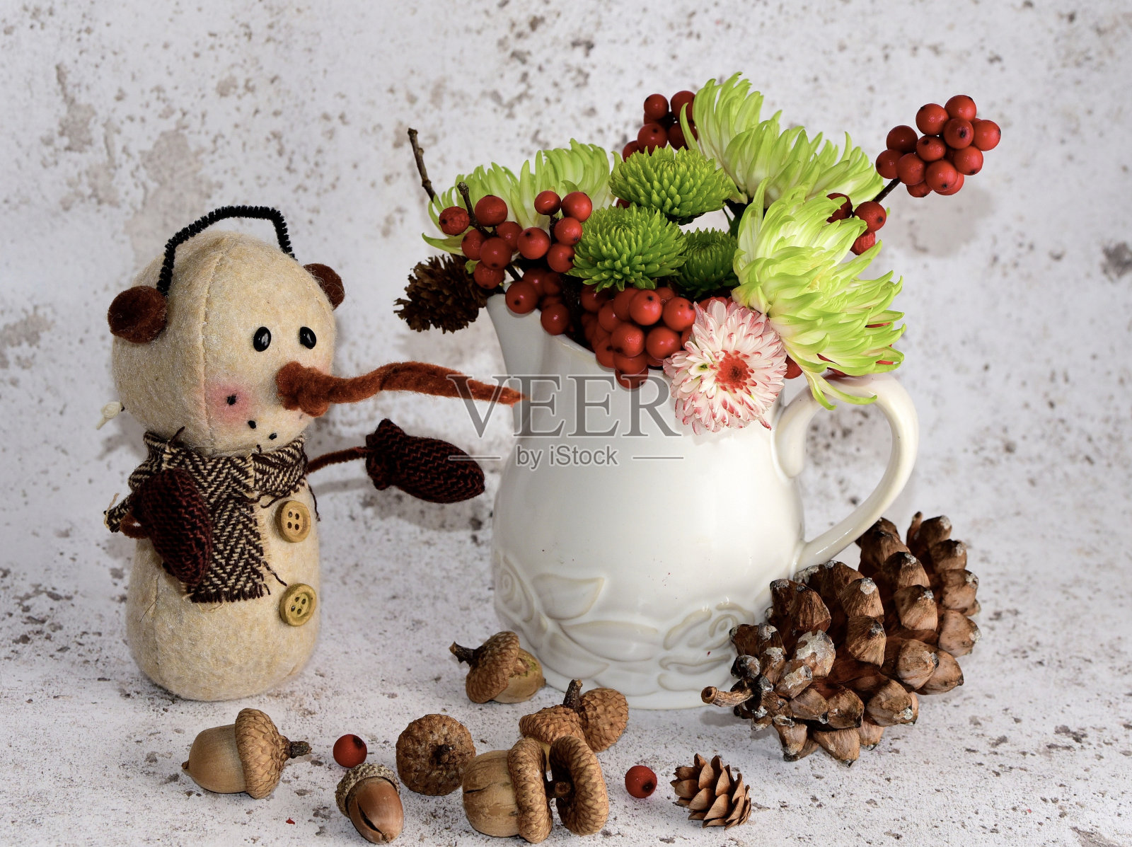 特写镜头是一个长鼻子的白色雪人，白色背景上有圣诞花照片摄影图片