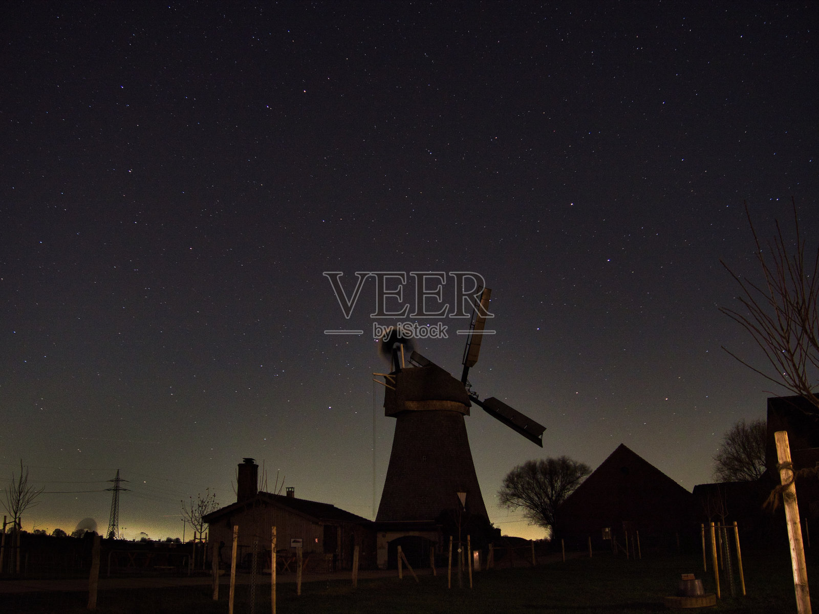 在繁星点点的夜空下，乡村地区风车的怪异景象照片摄影图片