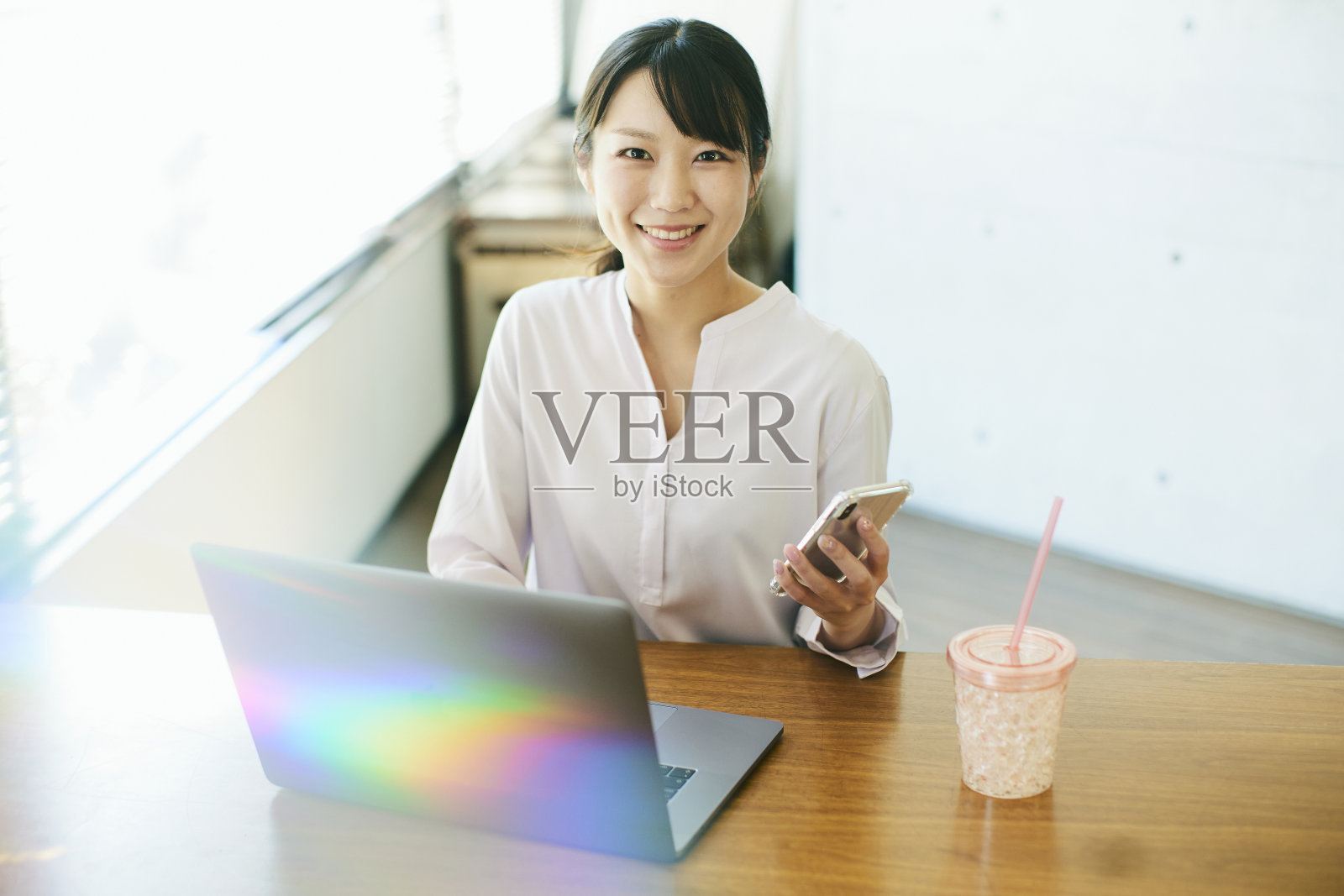 年轻的亚洲女人在靠窗的办公室工作照片摄影图片