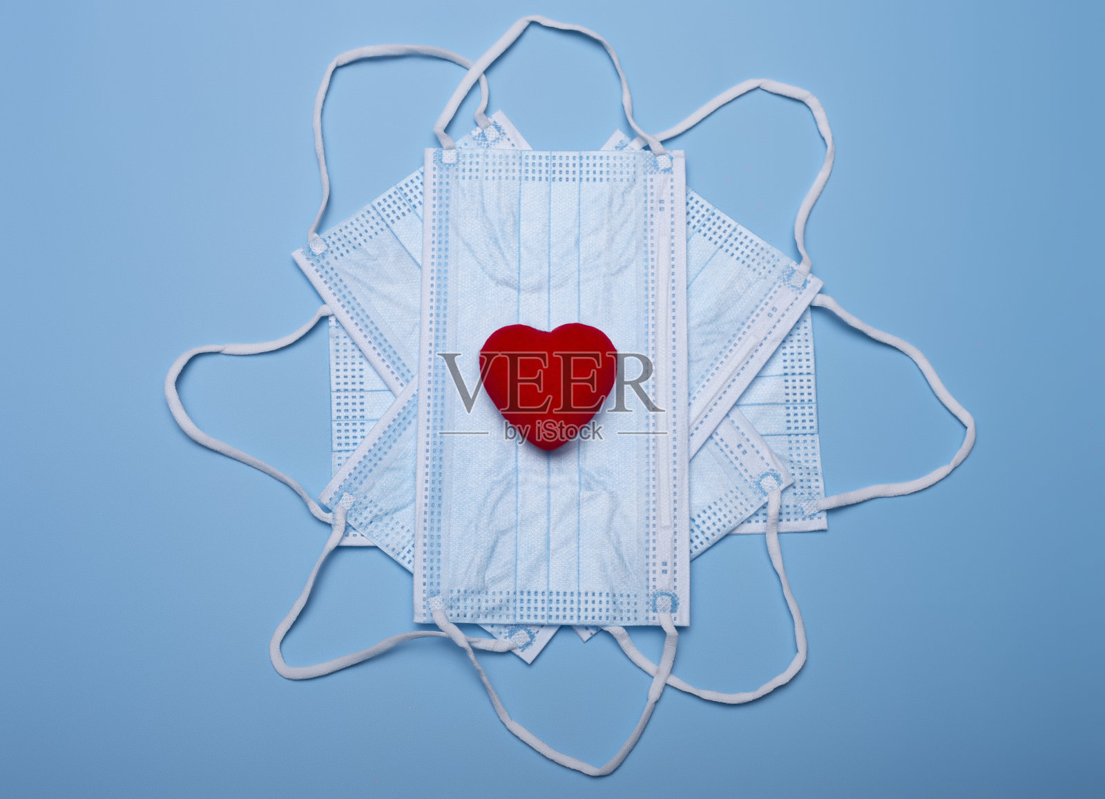 卫生口罩上的小红心装饰——大流行期间的情人节照片摄影图片